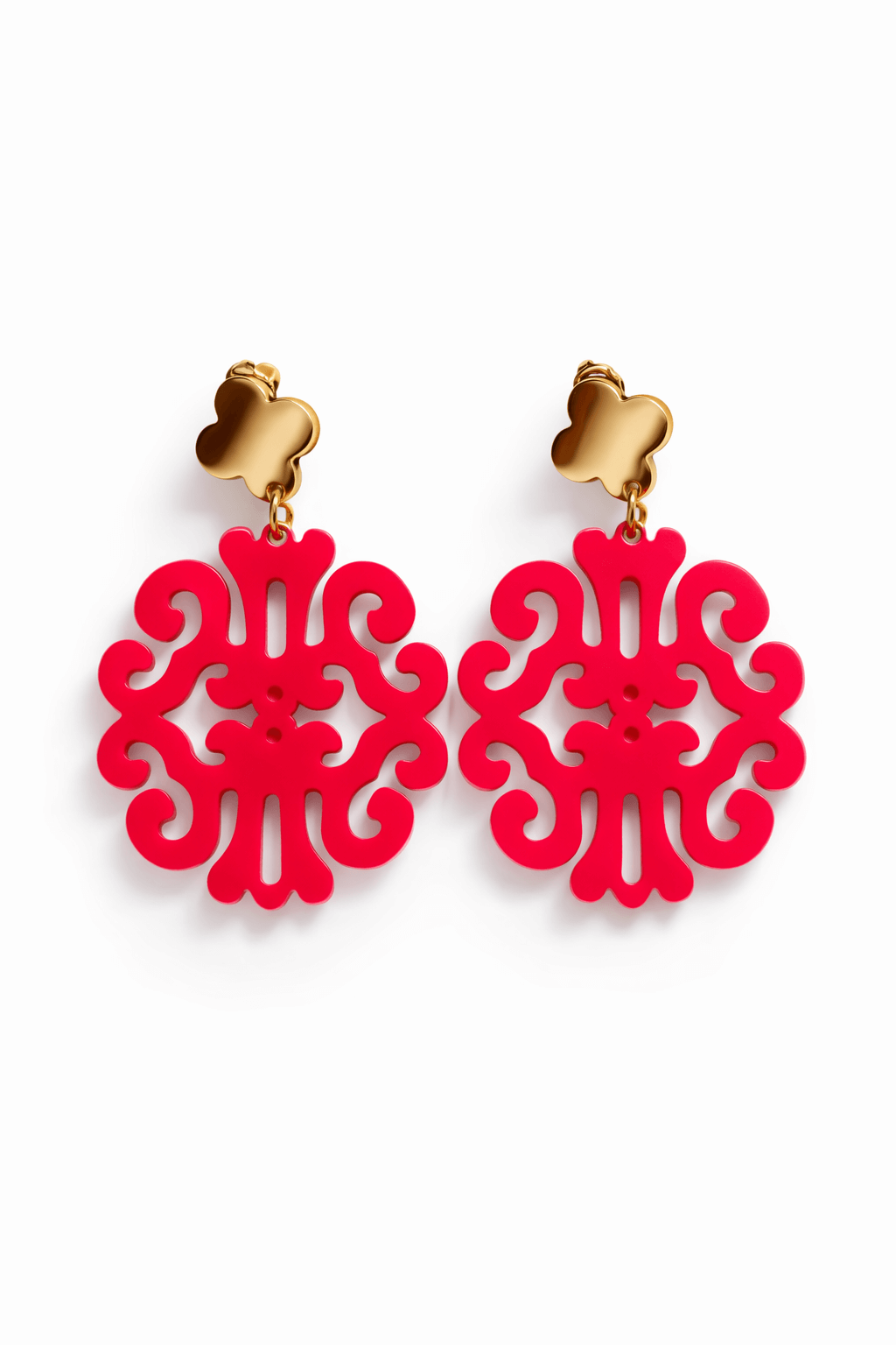 Paar hängende Ohrringe mit goldfarbenem Kleeblatt-Stecker und pinken ornamental durchbrochenem Anhänger vor weißem Hintergrund.
