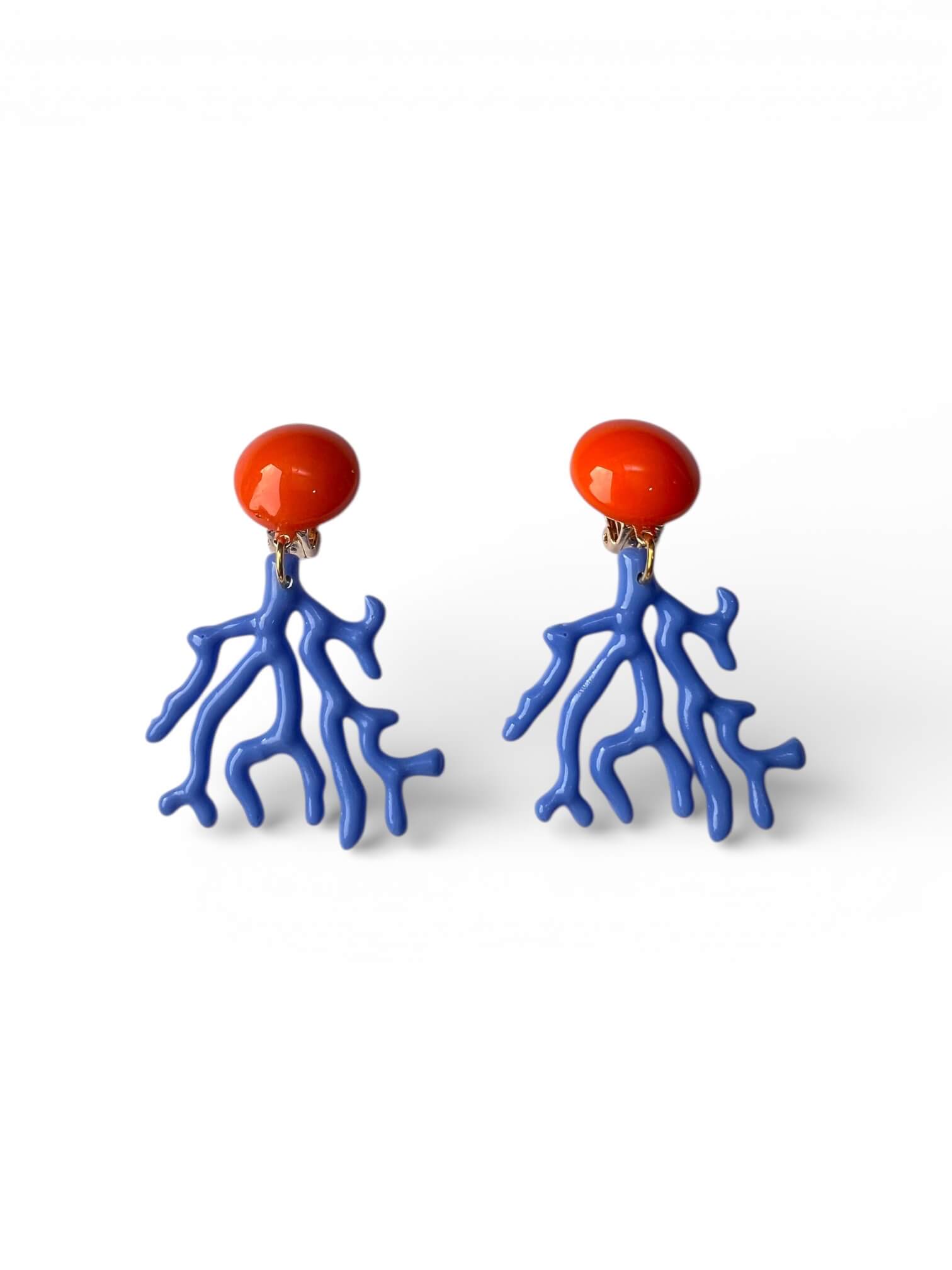 Paar blaue Clip-Ohrringe in Korallenform mit orangefarbenem, rundem Clipselement, freigestellt vor weißem Hintergrund.