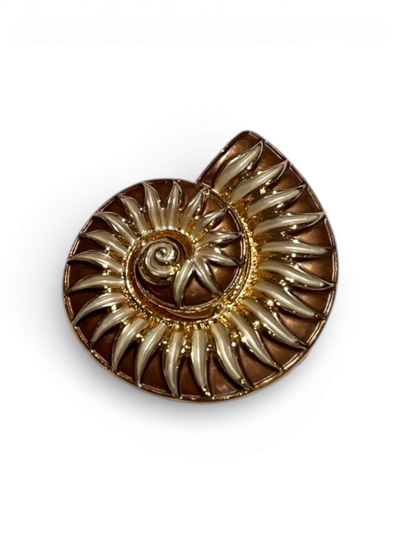 Magnetbrosche in Form einer stilisierten Muschel in Gold mit mehrfarbigen Emaille-Elementen in Braun Tönen, freigestellt vor hellem Hintergrund.