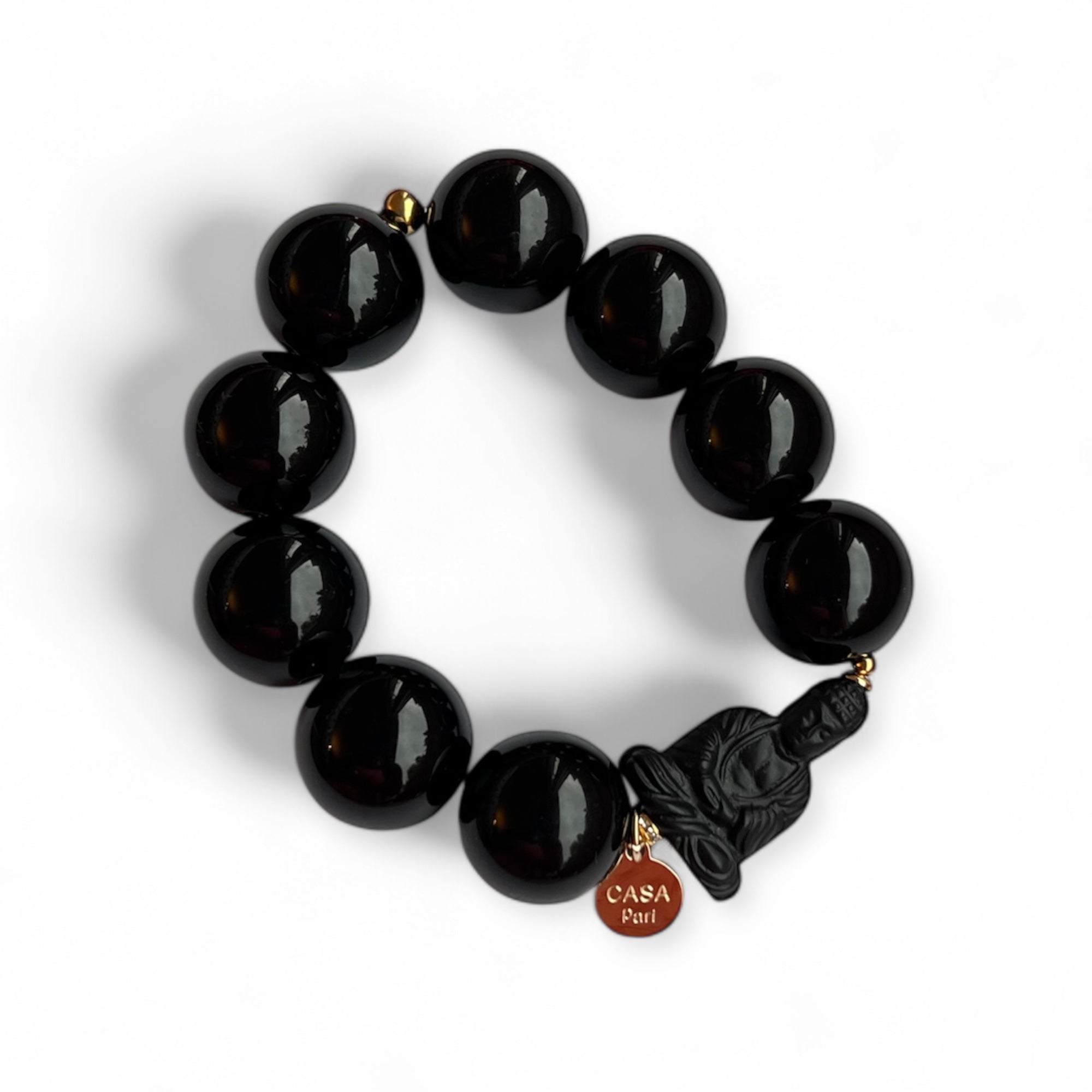 Schwarzes Armband aus glänzenden Kunstharzperlen mit einem kleinen Buddha Element. Handgefertigt von Casapari auf weißem Hintergrund.