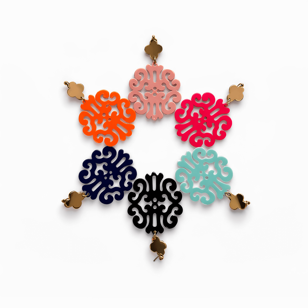 Sechs Paar hängende Ohrringe mit goldfarbenem Kleeblatt-Stecker und ornamental durchbrochenem Anhänger in Schwarz, Dunkelblau, Orange, Pink, Mintgrün und Rosé, angeordnet vor weißem Hintergrund.