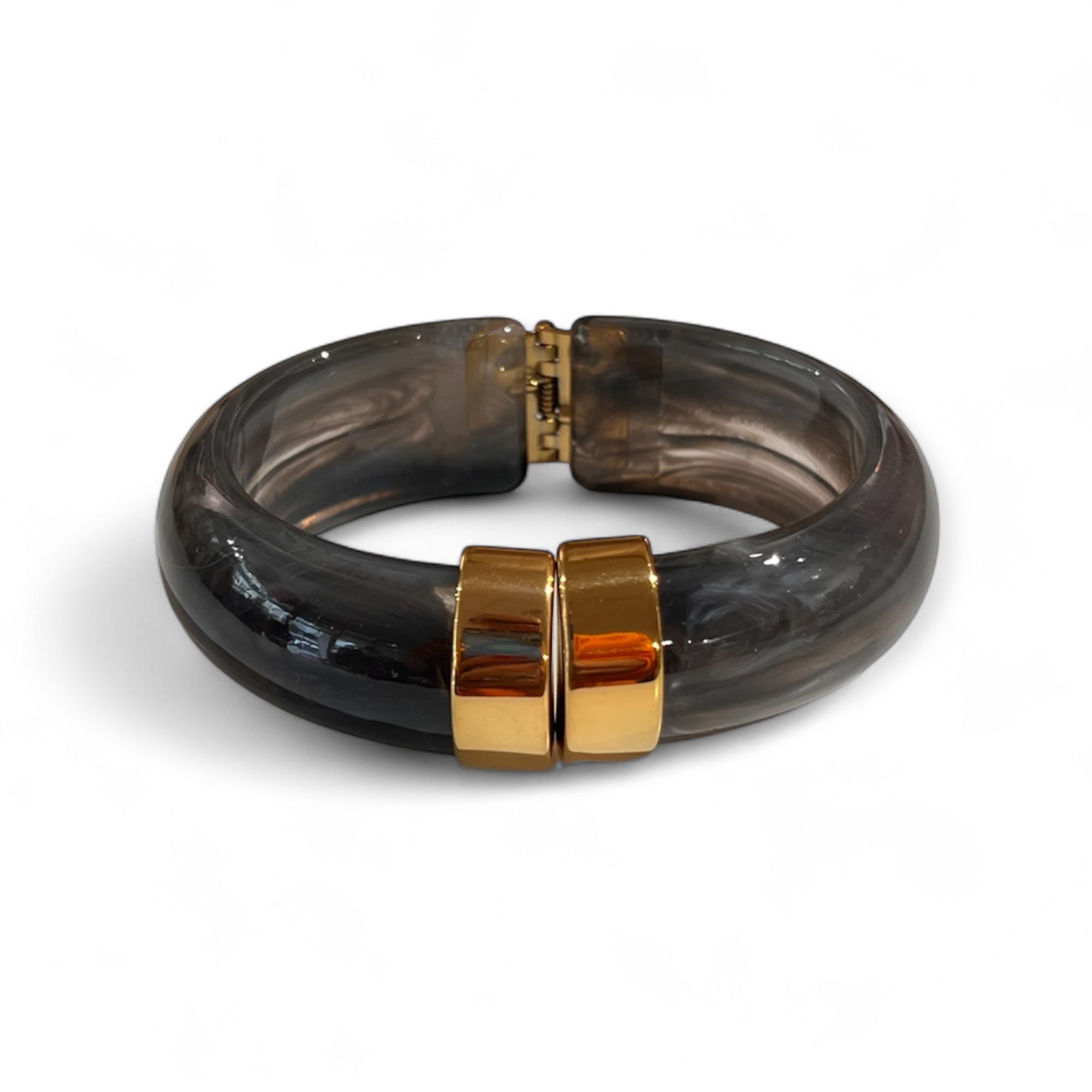 Klapp Armreif in Grau mit goldener Details. Auf weißem Hintergrund fotografiert.