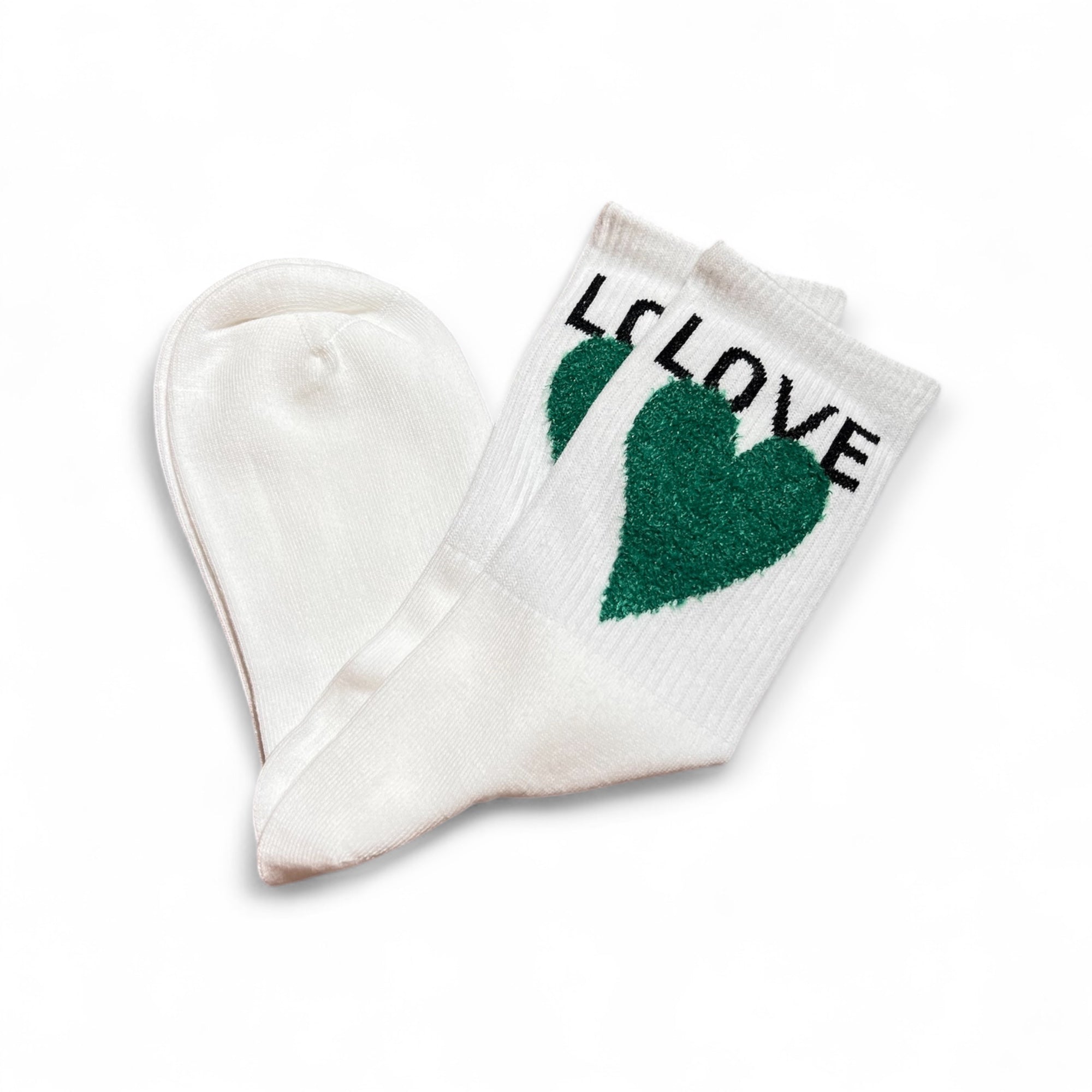 Weiße Strümpfe mit grünem Herzmotiv und dem Schriftzug LOVE am Bund. Flauschige Struktur auf dem Herz, flach liegend auf weißem Hintergrund.
