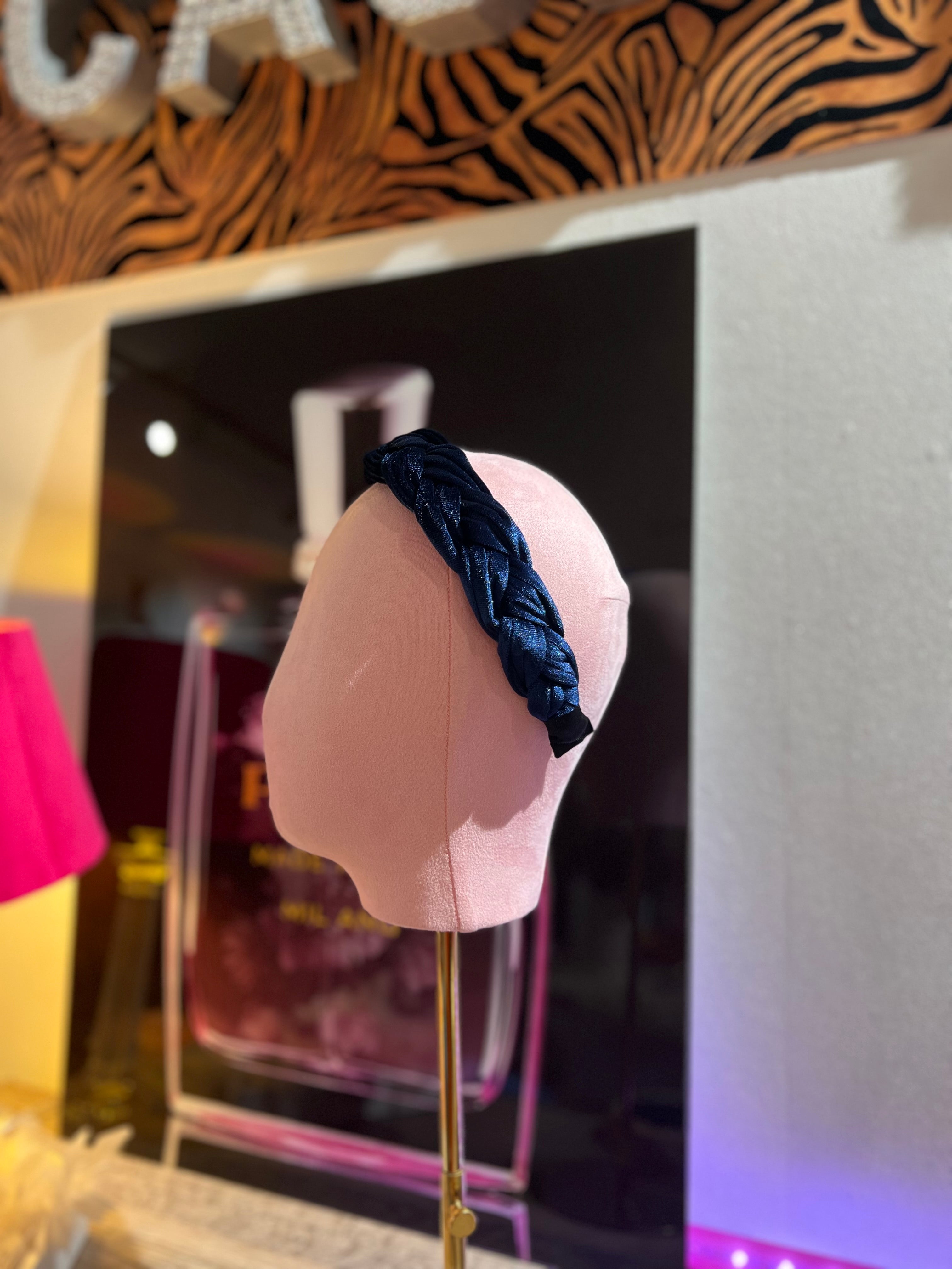 Puppenkopf trägt blauen Haarreifen fotografiert im stilvollen Hintergrund.