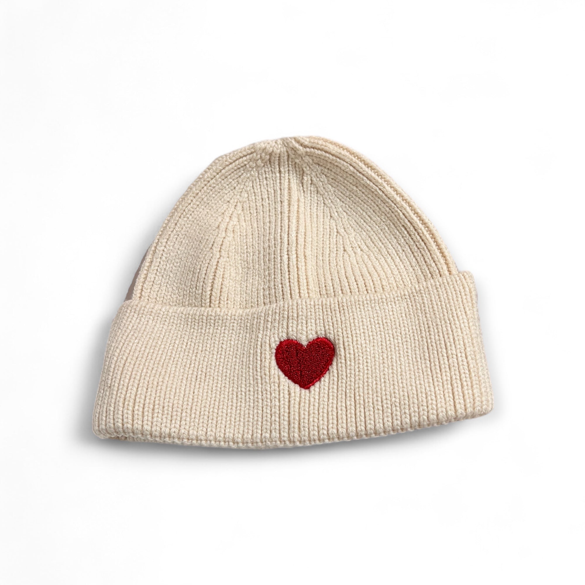 Offwhite Strickmütze aus Viskose mit aufgesticktem rotem Herz auf der Vorderseite, fotografiert auf weißem Hintergrund.