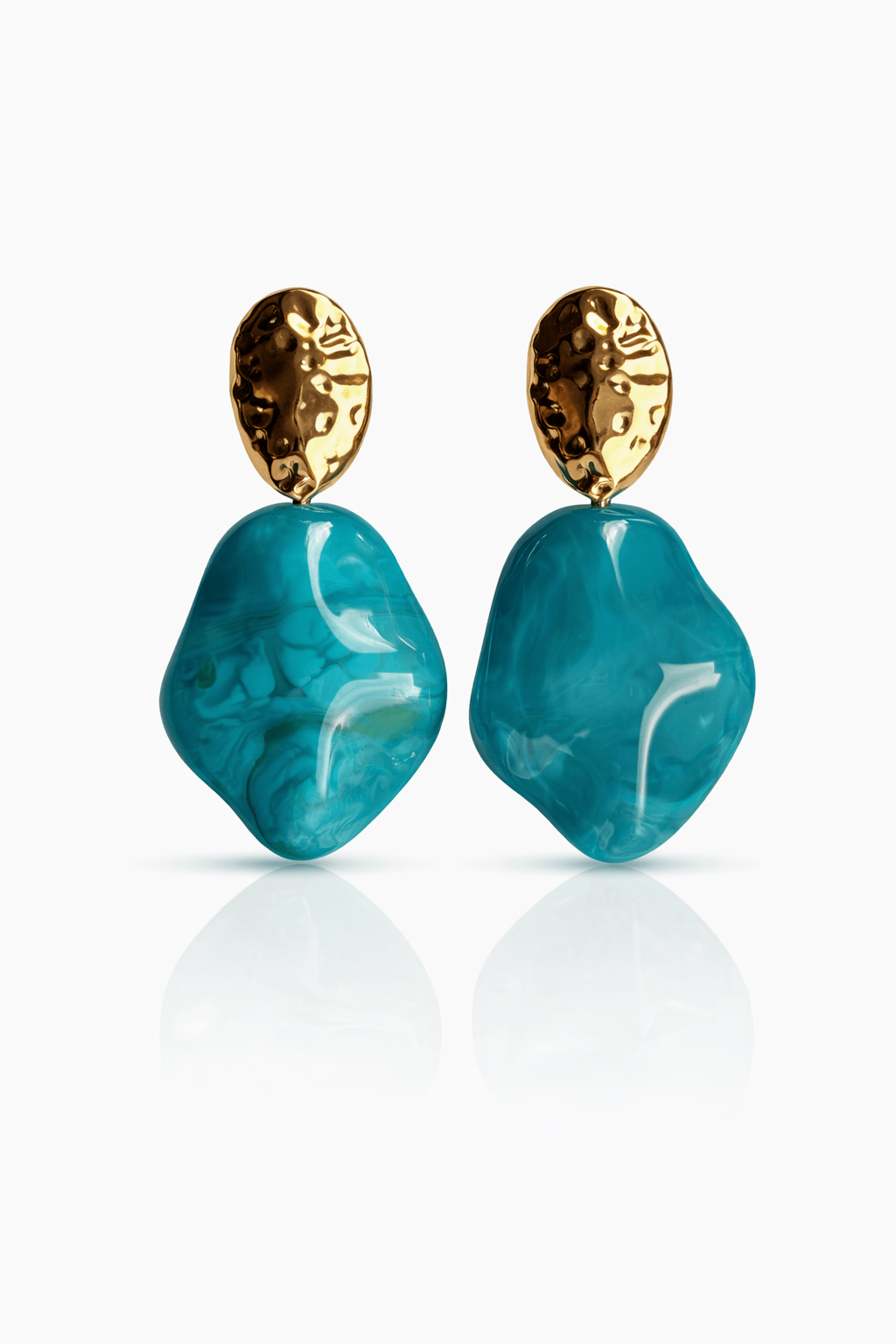 Paar Ohrstecker mit goldfarbenem, ovalem Stecker und türkisfarbenem, marmoriertem Anhänger in organischer Form auf weißem Hintergrund.