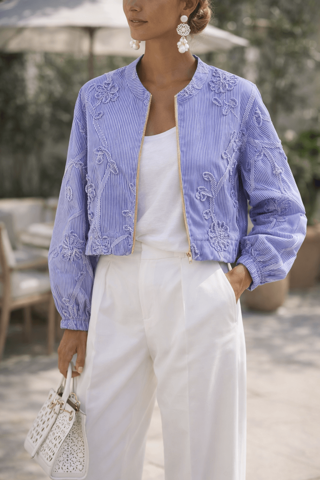 Leichte Casapari Jacke in Hellblau mit feinen Streifen, floralen Stickereien und goldenem Reißverschluss. Femininer Look für elegante Sommer-Outfits.