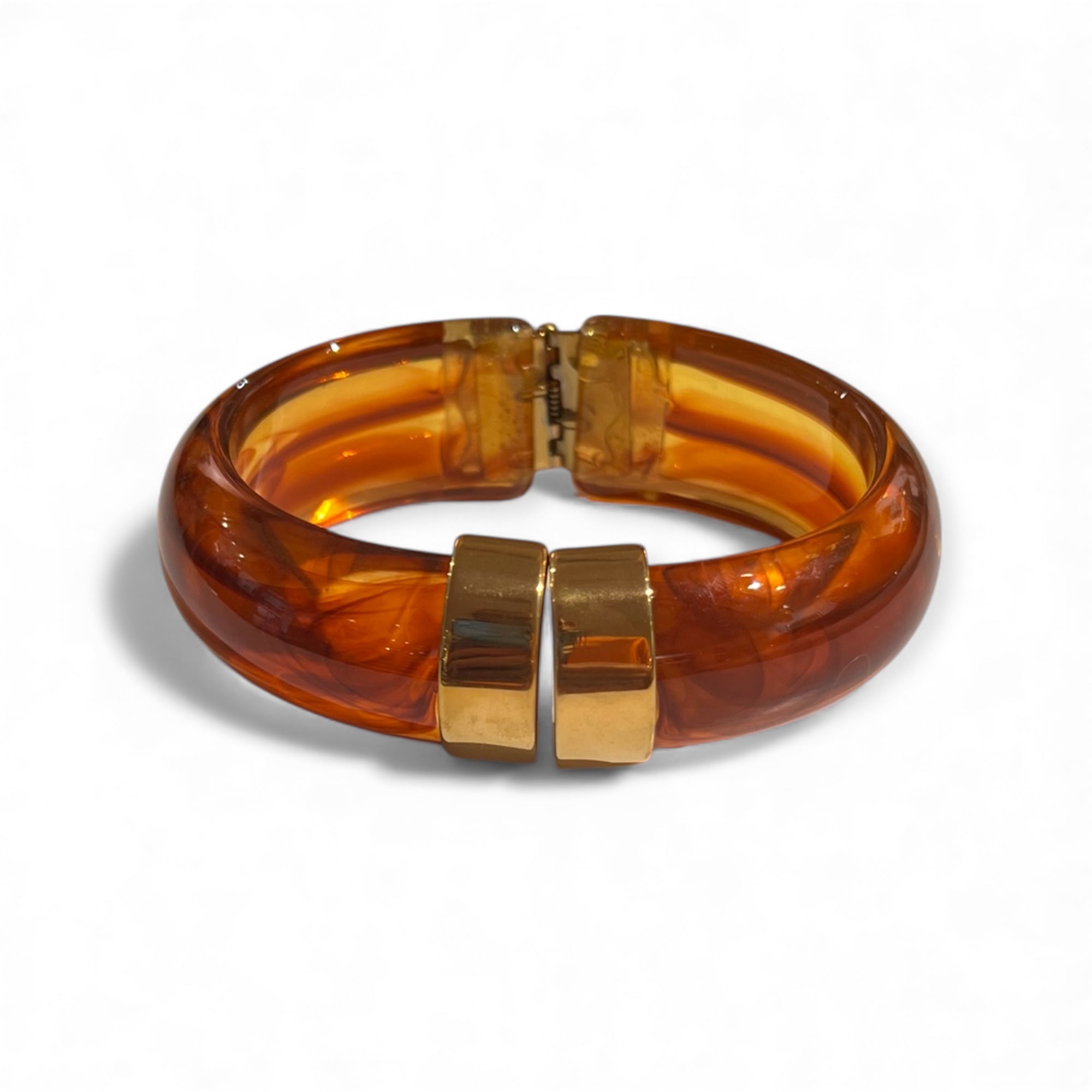 Klapp Armreif aus marmoriertem Kunstharz in Karamell mit goldfarbenen Details.