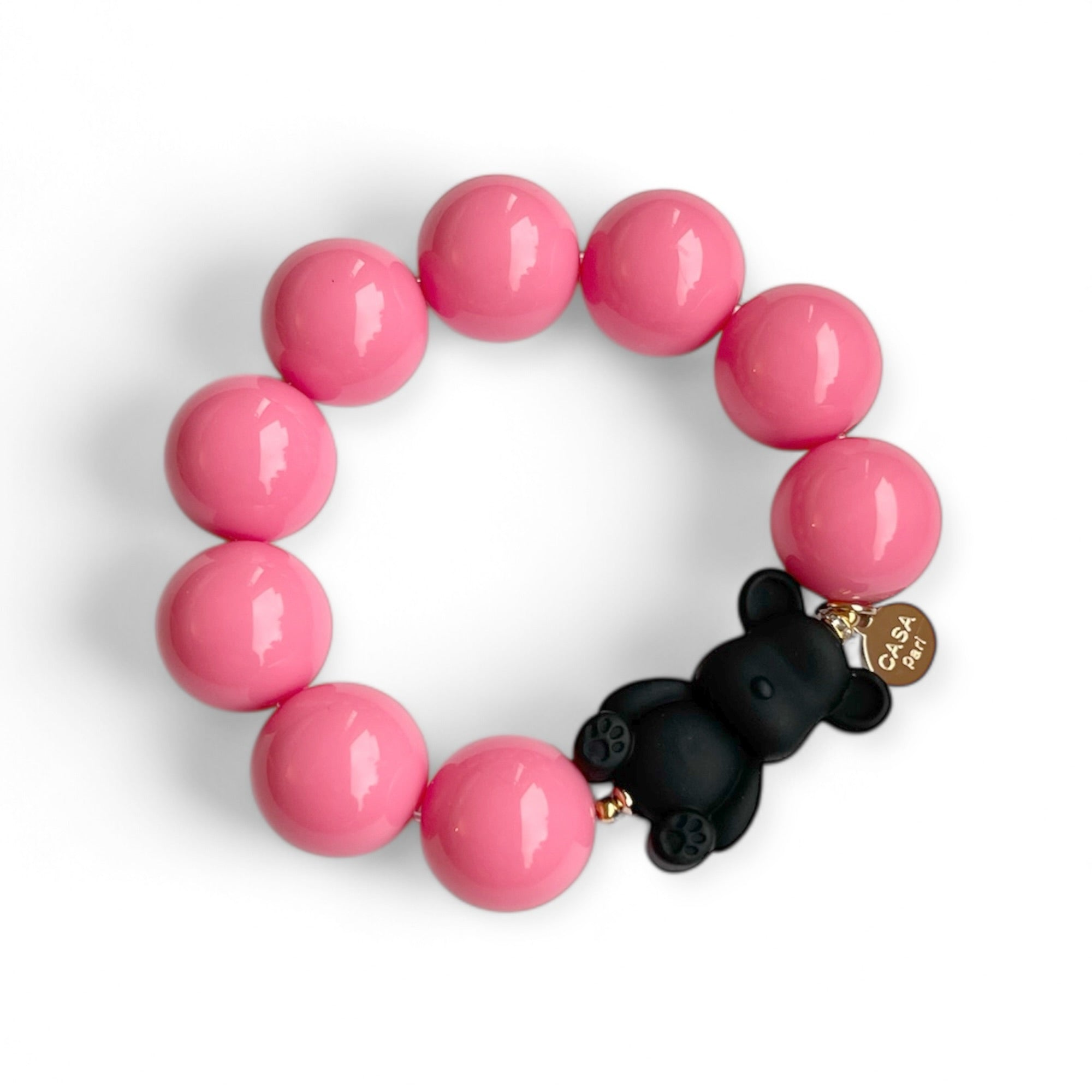 Armband aus rosa Kunstharzperlen mit einem kleinen schwarzen Bärenelement, handgefertigt von Casapari auf weißem Hintergrund.