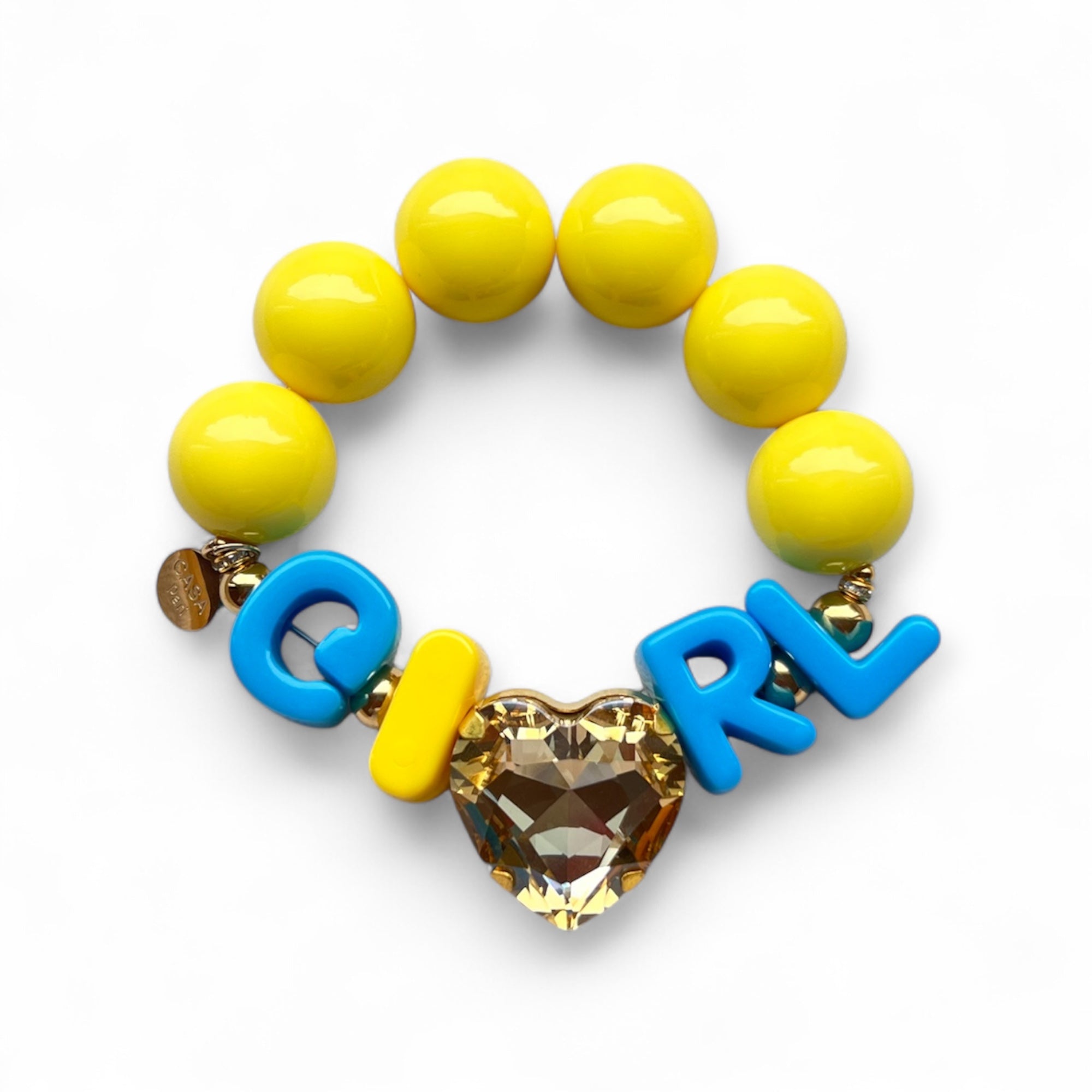 Gelbes Armband aus großen, glänzenden Perlen mit goldfarbenen Details. In der Mitte Buchstaben, die das Wort GIRL bilden, und ein funkelnder, herzförmiger Stein in Topaz.