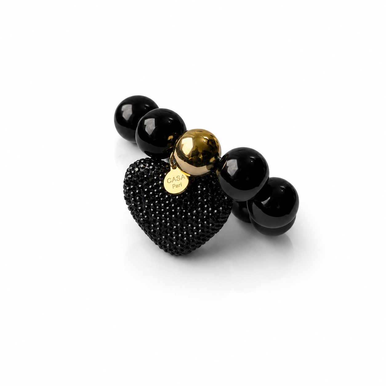 Schwarzes elastisches Statement-Armband mit glänzenden 20-mm-Resin-Perlen, großem schwarzen Strassherz und goldfarbenen Details.