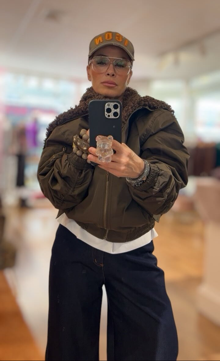 Frau at Bomber Jacke mit Fell an und macht ein Selfie
