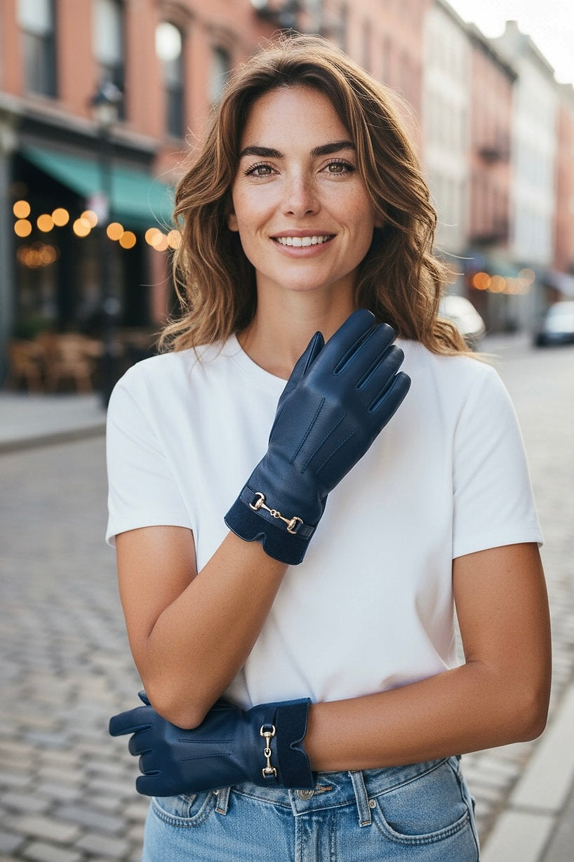 Frau trägt blaue Kunstleder Handschuhe mit silberner Schnalle.