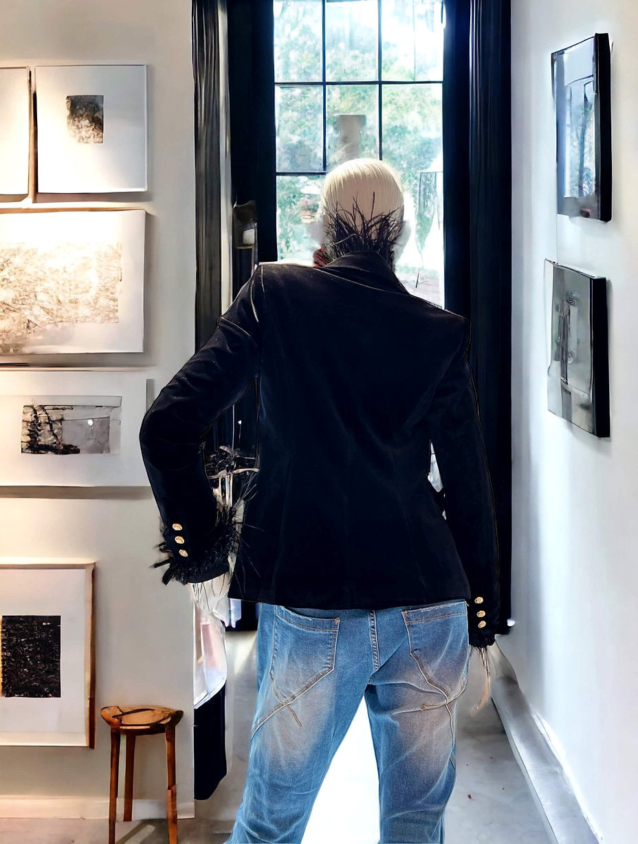 Rückenansicht des CASAPARI® Samtblazers in Schwarz. Taillierter Schnitt, weicher Samt mit edlem Schimmer. Goldene Knöpfe am Ärmel sichtbar.