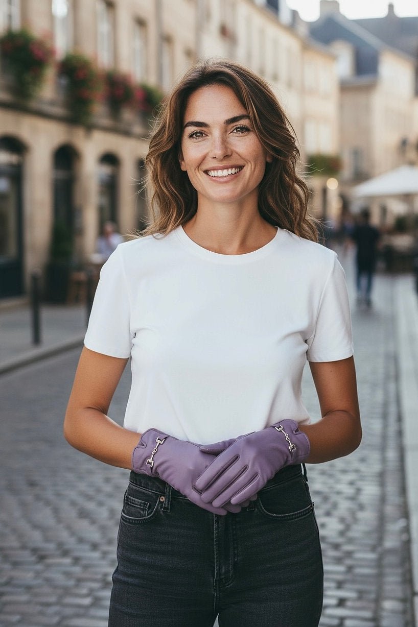 Frau trägt weißes Shirt, Jeans und fliederfarbene Kunstleder Handschuhe.