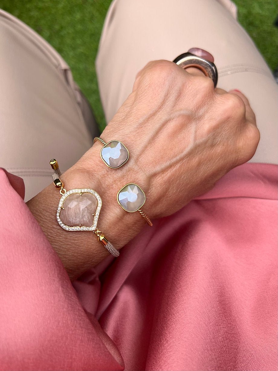 Nahaufnahme eines handgefertigten Armband Set mit Cat Eye Steine in Caffè Latte und Taupe. Getragen am Handgelenk, schlichte Farben, goldenen Details, eleganter Look.