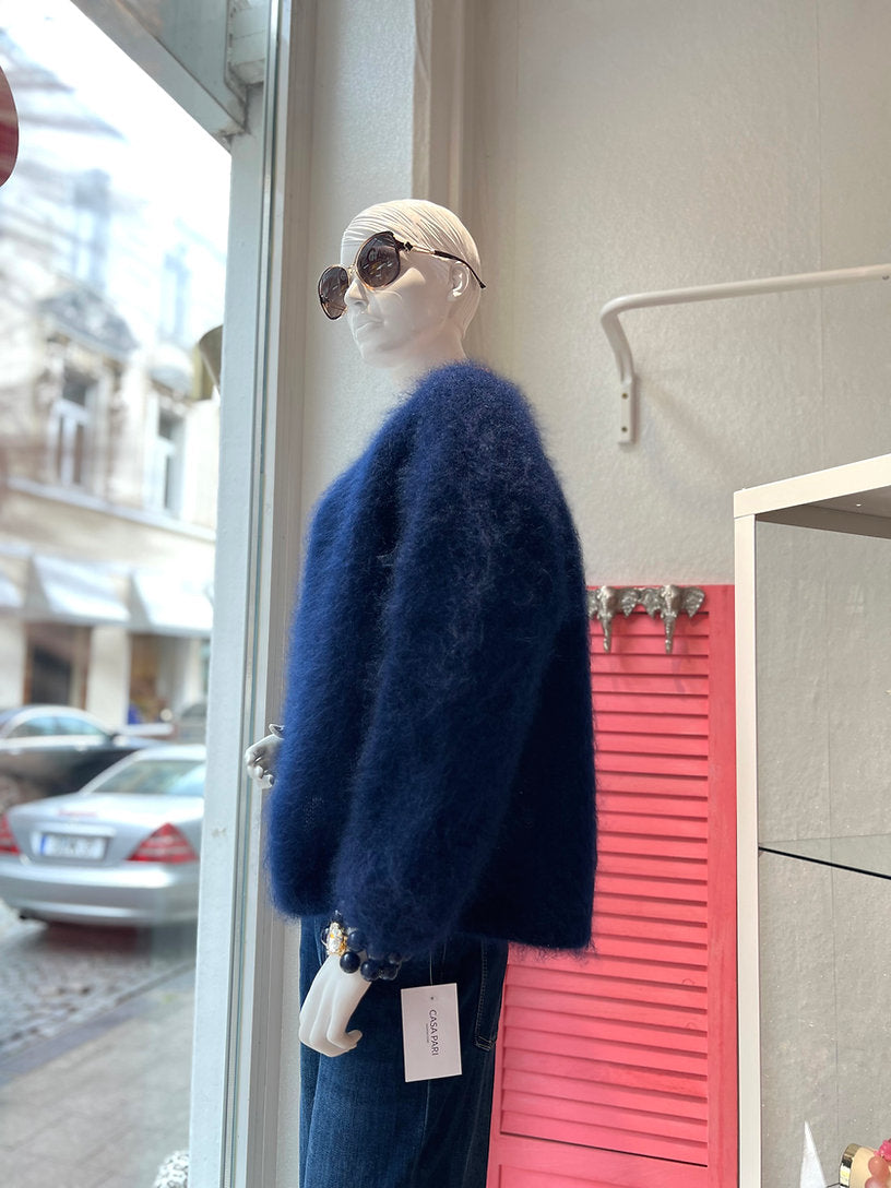 Schaufensterpuppe trägt dunkelblaue Mohair Jacke mit Jeans Hose. Vor einem Schaufenster fotografiert.