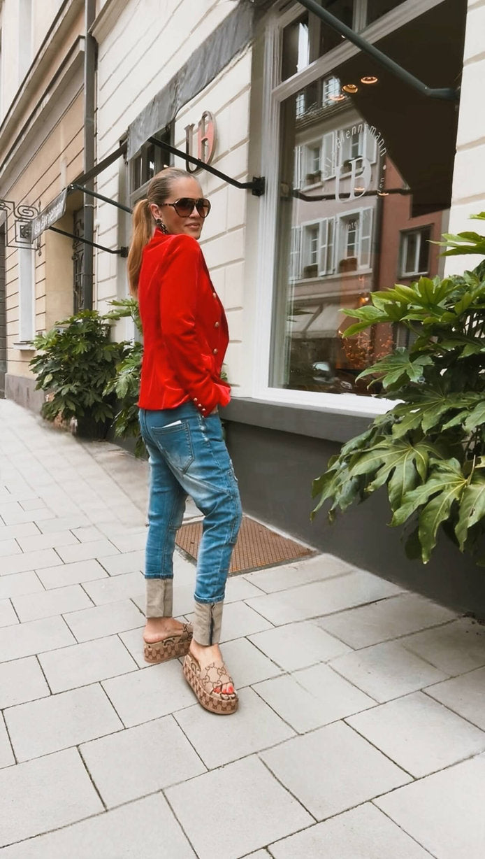 Seitliche Ansicht des CASAPARI® Samtblazer in leuchtendem Rot. Taillierter Schnitt, weicher Samt, goldene Knöpfe akzentuiert die Silhouette.