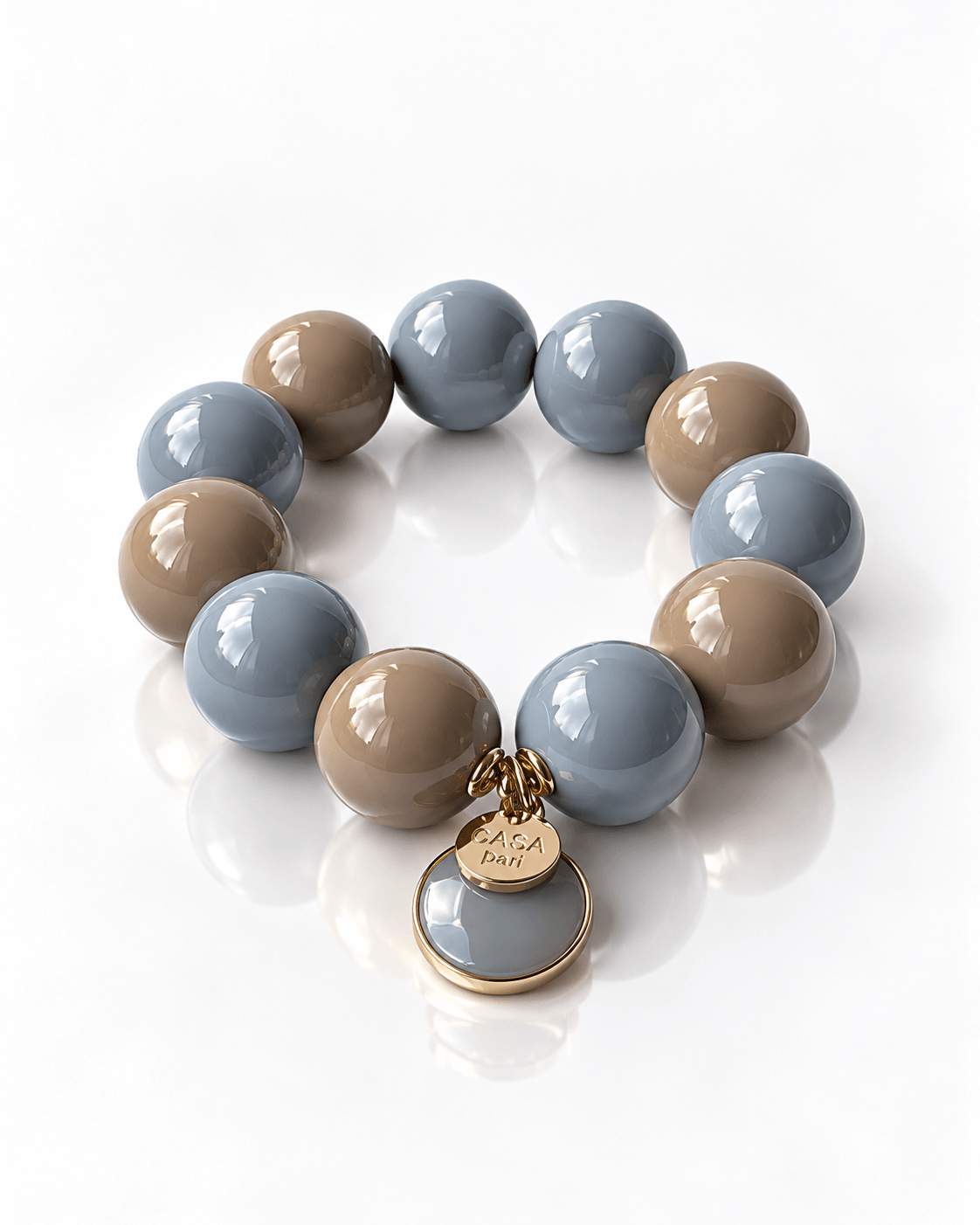 Armband aus großen Resin-Perlen in Cashmere Grey und Hellblau mit rundem Achat-Anhänger und goldfarbenem Casapari Charm.