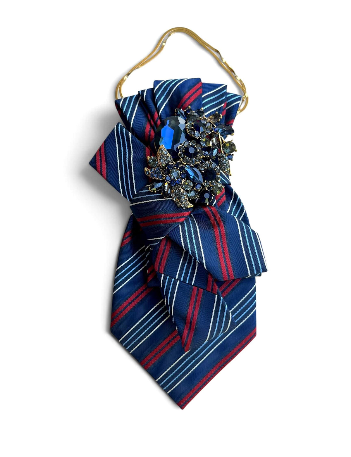 Statement-Krawatte aus Vintage-Seide in Royalblau mit roten und weißen Streifen, Schleife sowie dunkelblauer Schmuckbrosche an goldfarbener Kette.