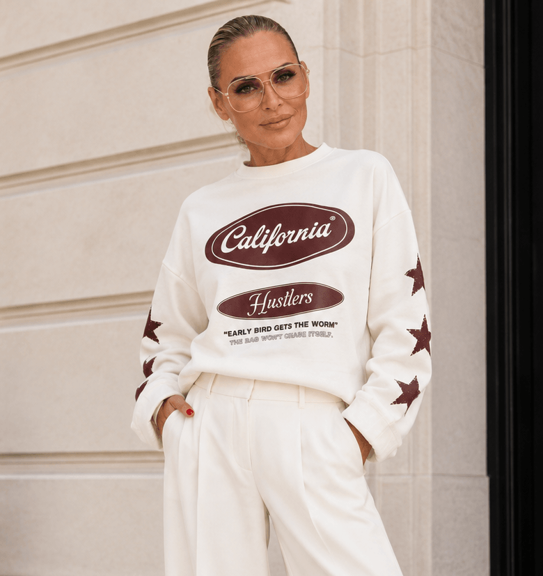 Cremebeiger California Sweaty von Casapari mit Frontprint und Sternen an den Ärmeln, lässig kombiniert zur weißen Marlene.