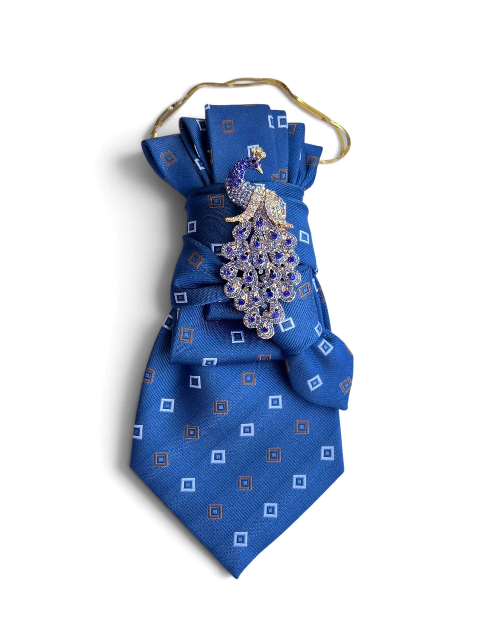 Blaue Statement-Krawatte mit geometrischem Muster, goldfarbener Kette und funkelnder Pfauenbrosche in Blau und Gold.