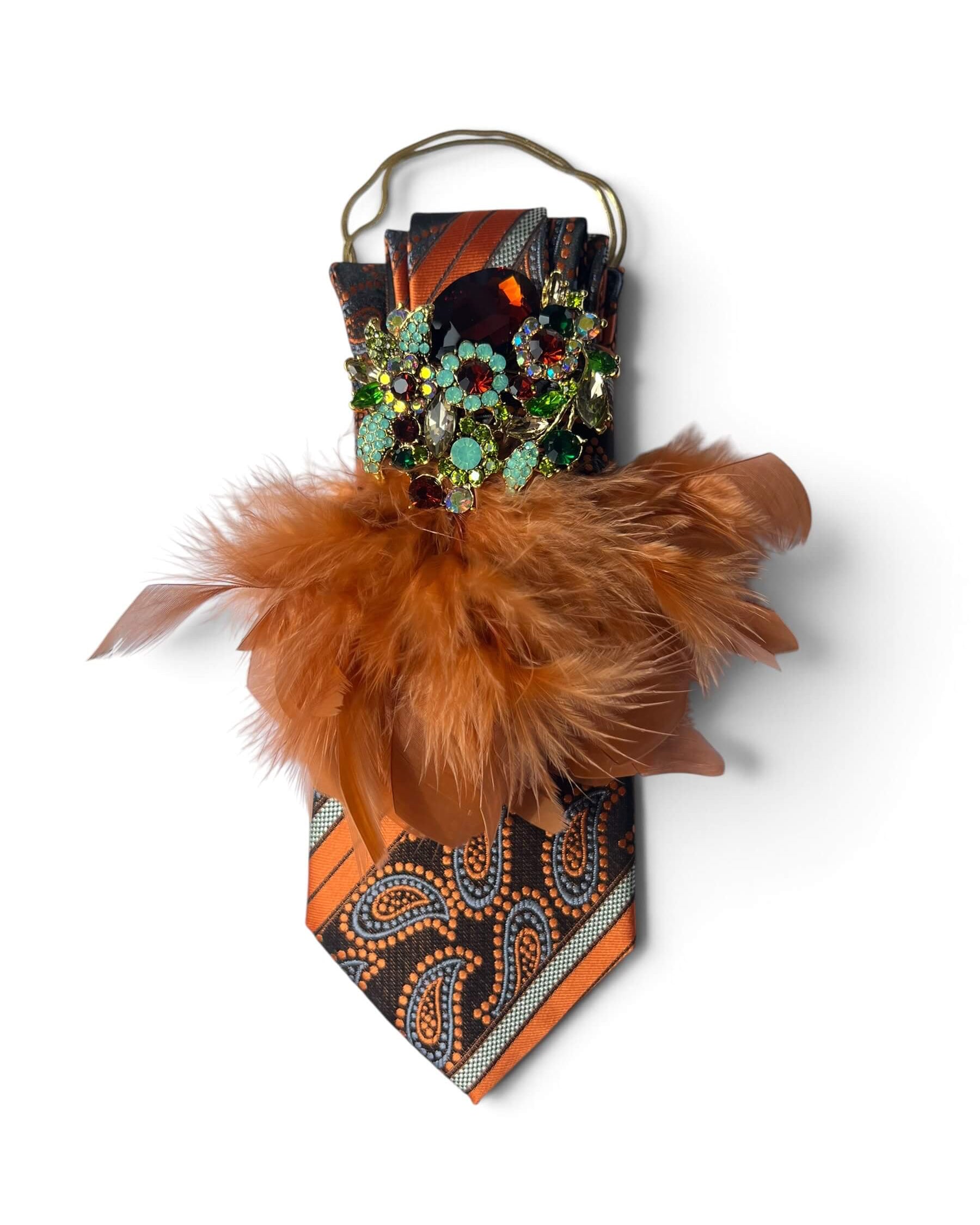 Vintage-Seidenkrawatte in Cognac und Schwarz mit Paisleymuster, opulenter Schmuckbrosche in Bordeaux, Türkis und Grün sowie braunen Federn.