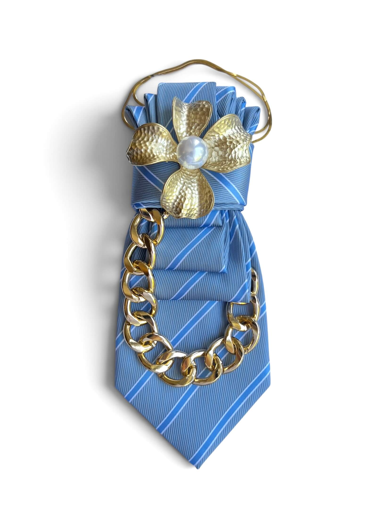 Hellblaue gestreifte Statement-Krawatte mit goldfarbener Kette und großer goldener Blütenbrosche mit Perle.