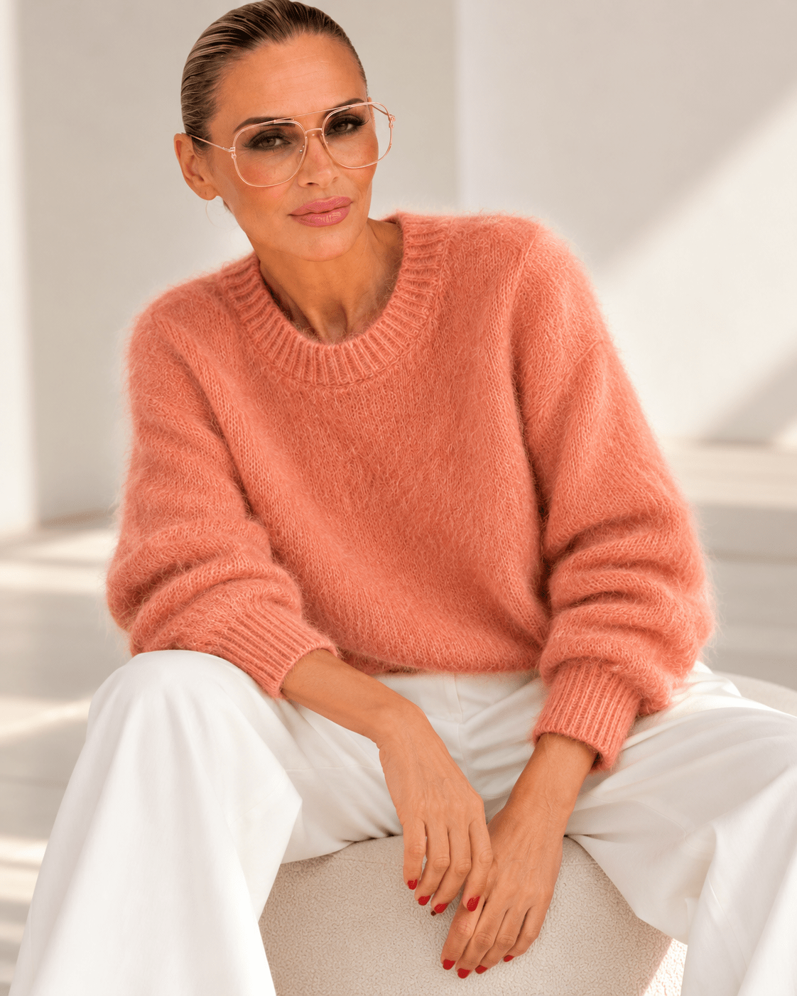 Model trägt korallfarbenen Kid-Mohair-Pullover mit Rundhalsausschnitt