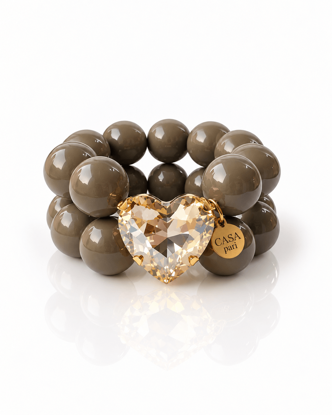Armband aus großen dunkel-taupefarbenen Perlen mit facettiertem Crystal Heart in Champagner und goldenem Casapari-Anhänger.
