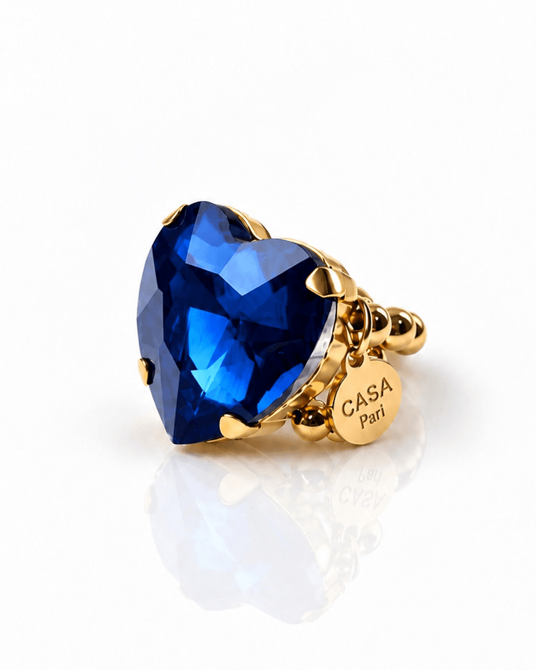 Goldfarbener Crystal Heart Ring mit großem facettiertem Herzstein in intensivem Royalblau und elastischem Perlenring