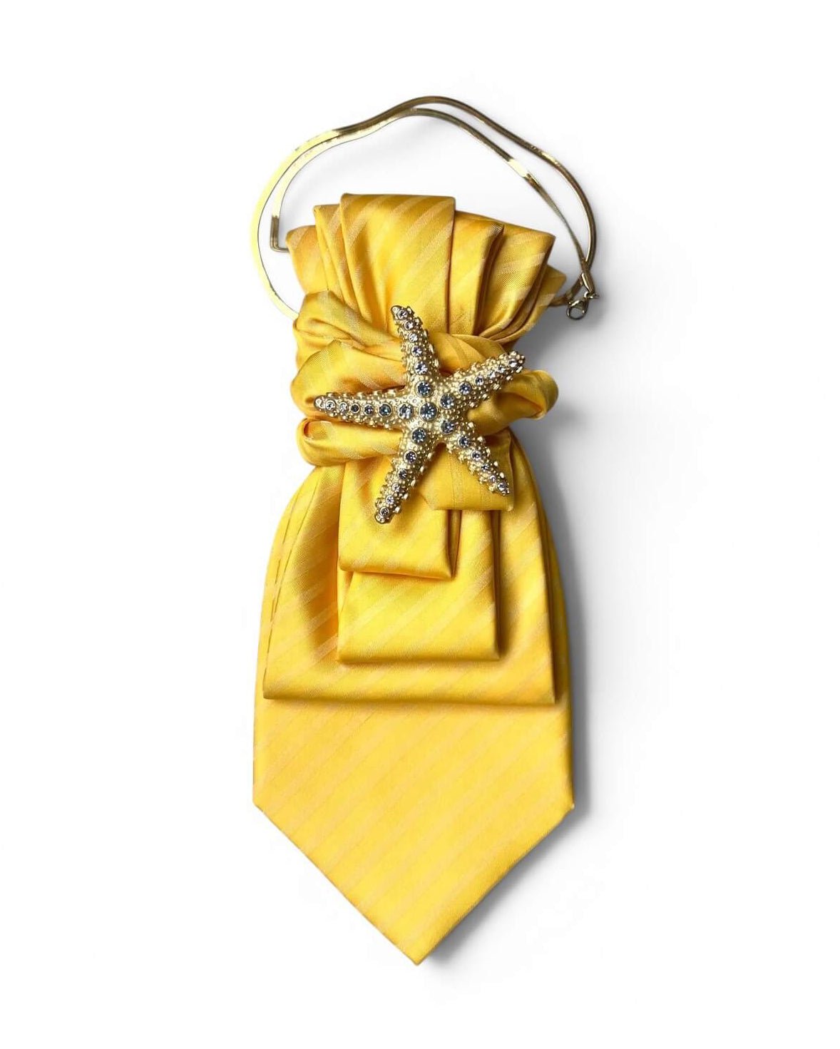 Gelbe Krawatte mit dezentem Streifenmuster und silberfarbener Seestern-Brosche mit funkelnden Kristallen. Die Krawatte ist mit einer feinen goldfarbenen Kette kombiniert und vor hellem Hintergrund freigestellt fotografiert.