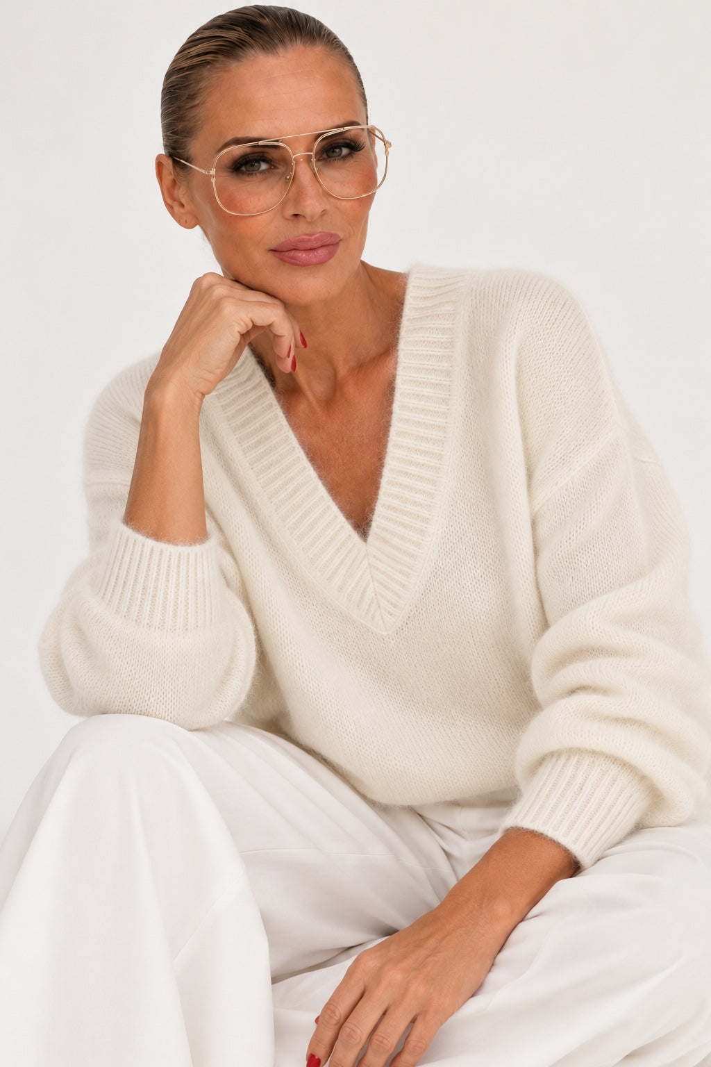 Model mit Pilotenbrille trägt cremefarbenen Kid-Mohair-Pullover mit V-Ausschnitt