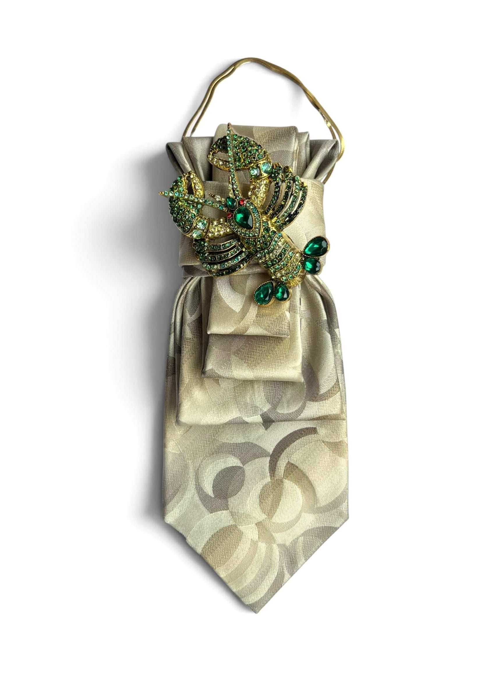 Cremefarbene Vintage-Seidenkrawatte von Casapari mit großer Brosche in Smaragdgrün und Gold sowie goldfarbener Kette.