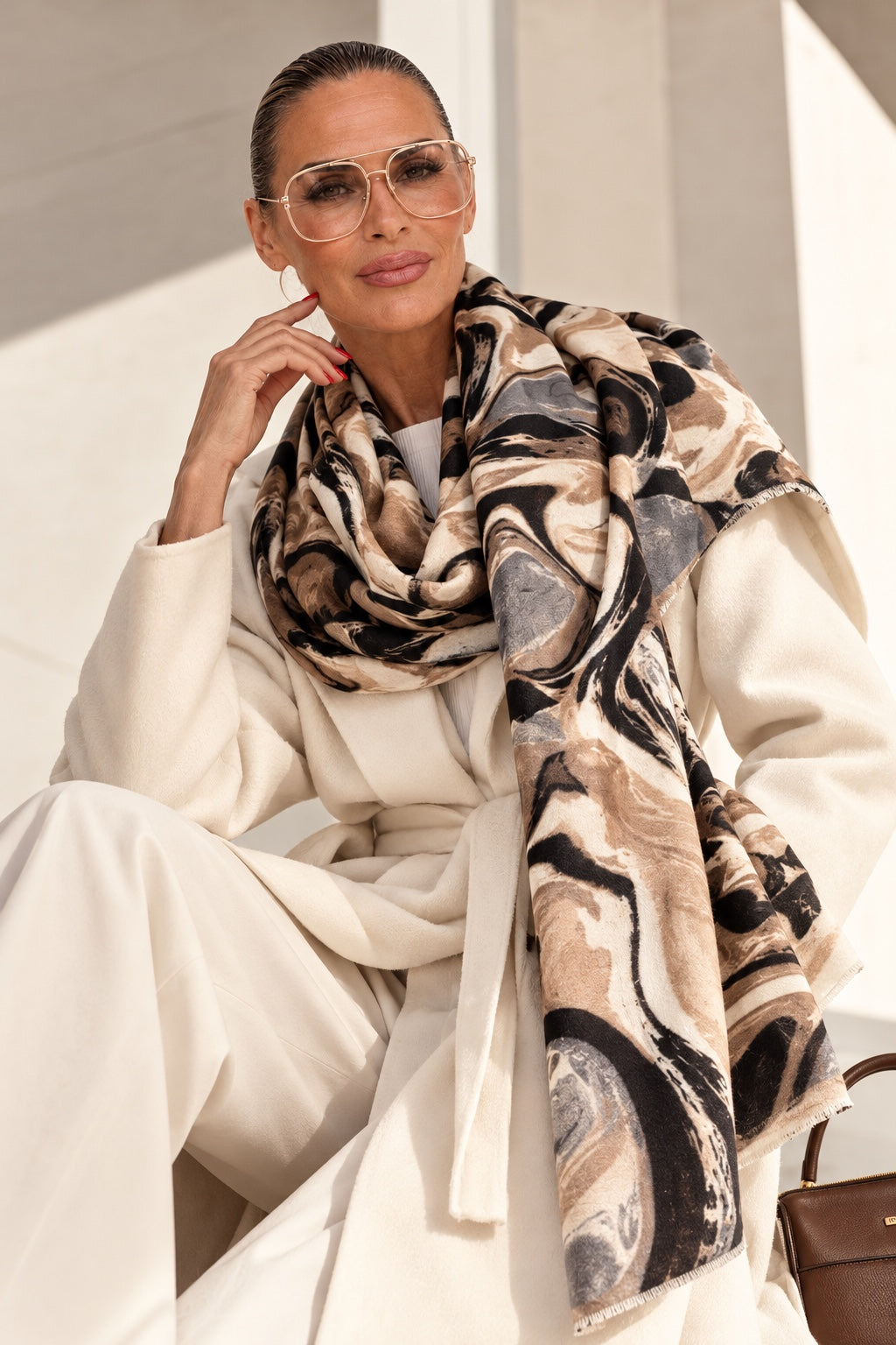 Model trägt Marble Statement Schal zu cremeweißem Wollmantel