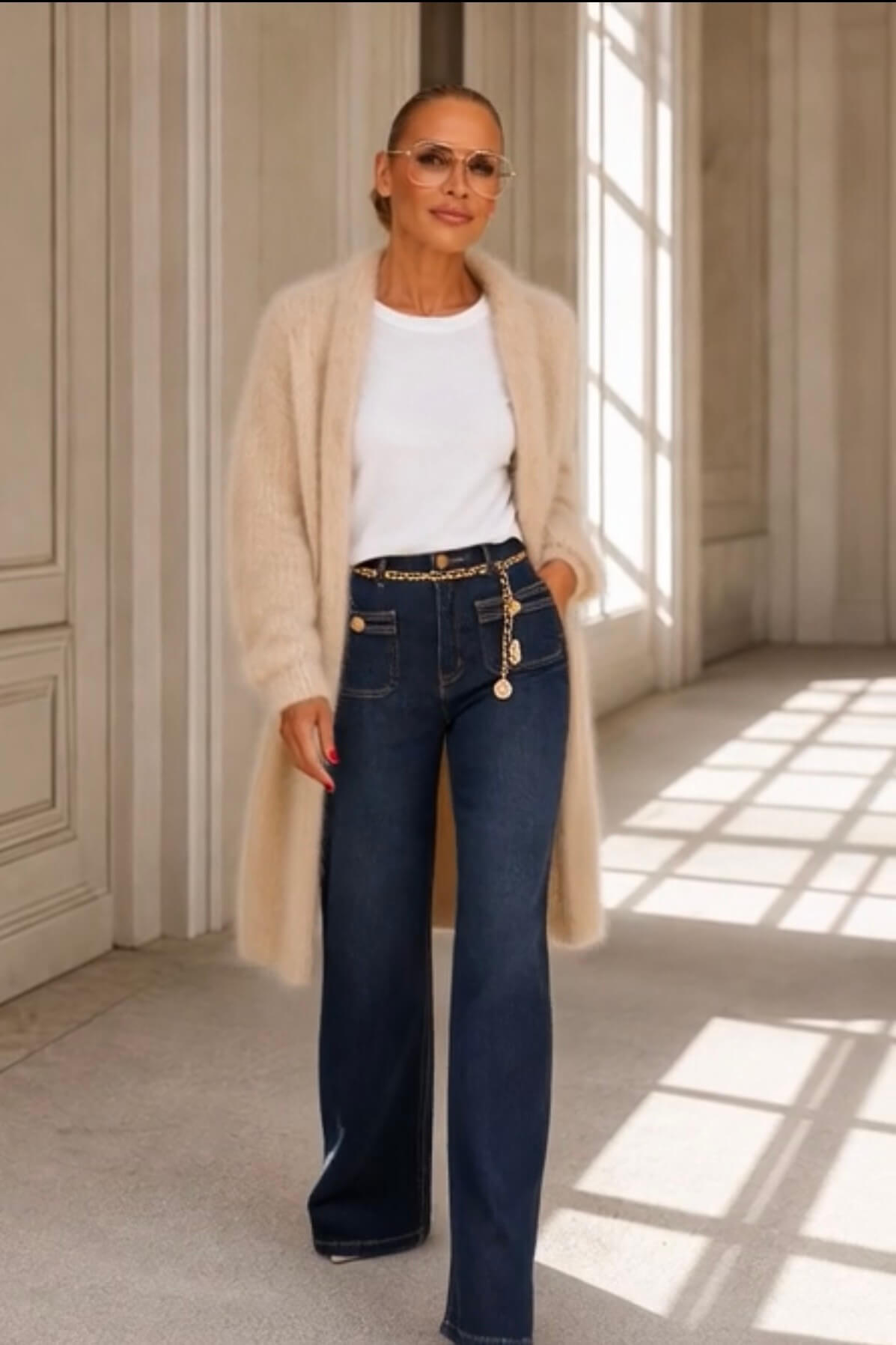 Dunkelblaue Marlene Jeans mit geradem weitem Bein, hohem Bund und goldfarbenen Schmuckdetails.