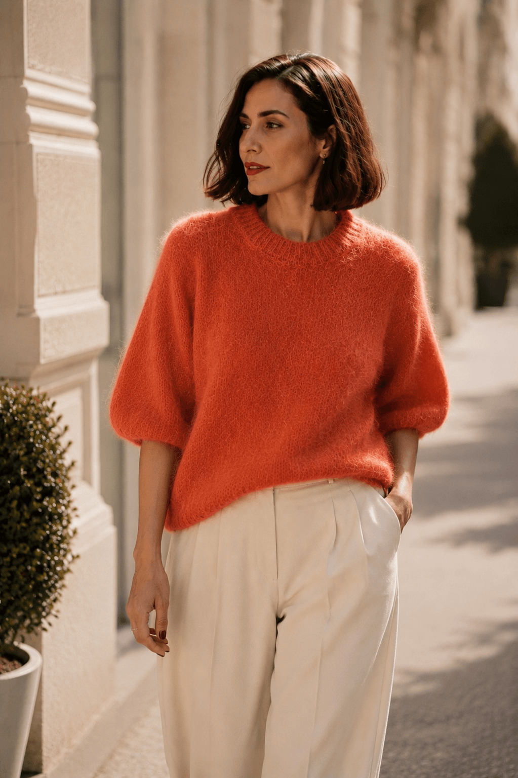 Korallfarbener Milano Kid Mohair Pullover mit Rundhalsausschnitt und halblangen Ärmeln, kombiniert mit einer cremefarbenen Marlenehose.