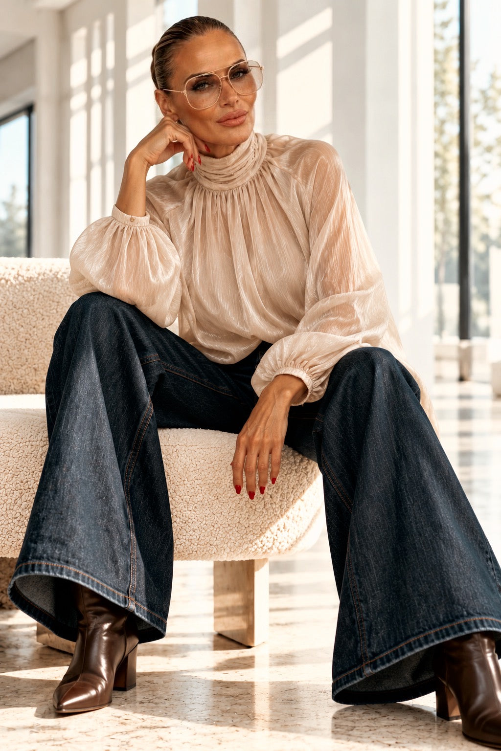 Sophisticated Monroe Bluse in Hell Cream, Model sitzend mit weiter dunkler Jeans