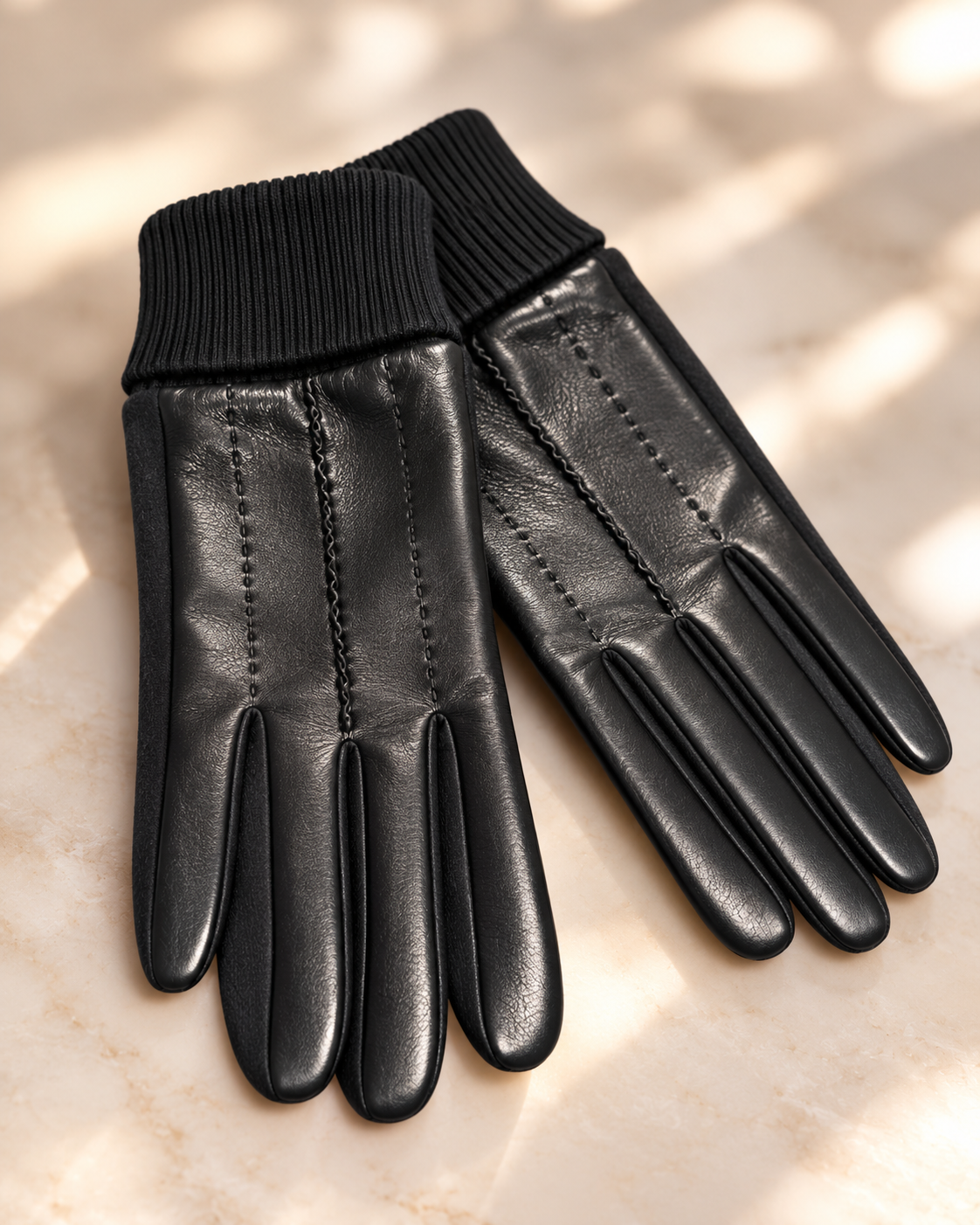 Schwarze Soft Touch Handschuhe auf hellem weichgezeichnetem Untergrund
