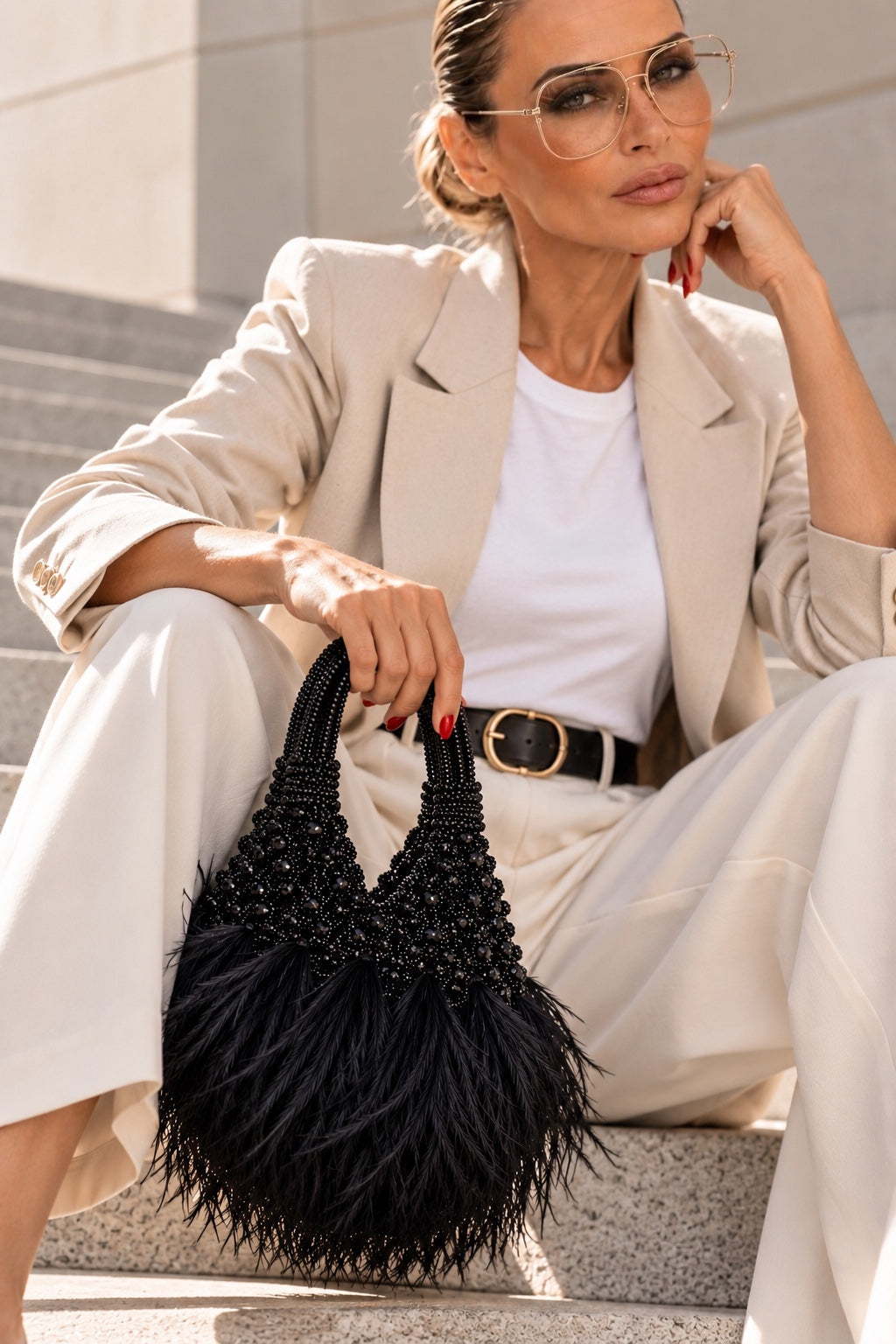 KI-generiertes Modelbild: THE BLACK SWAN Statement Bag, sitzend auf einer Treppe