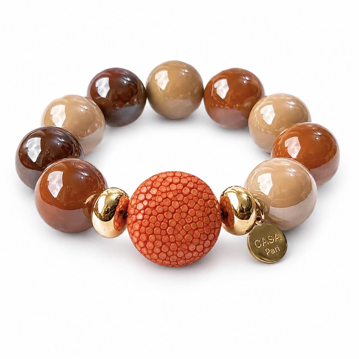 Perlen Armband in verschiedenen braun Tönen mit einer orangenen Rochen Lederperle auf weißem Hintergrund fotografiert