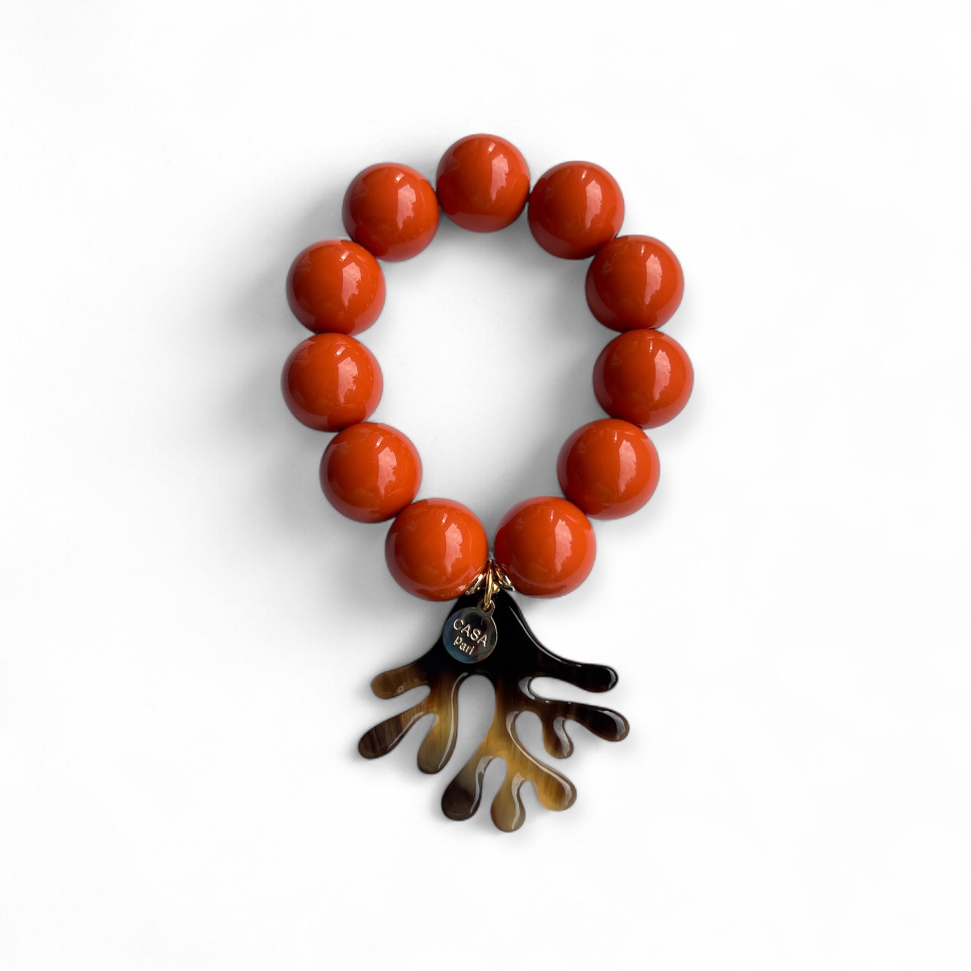 Armband mit großen Kunstharz Perlen in Korallenfarben mit echtem Büffelhorn Anhänger in Korallenform. Handgefertigtes Schmuckstück von CASAPARI®.