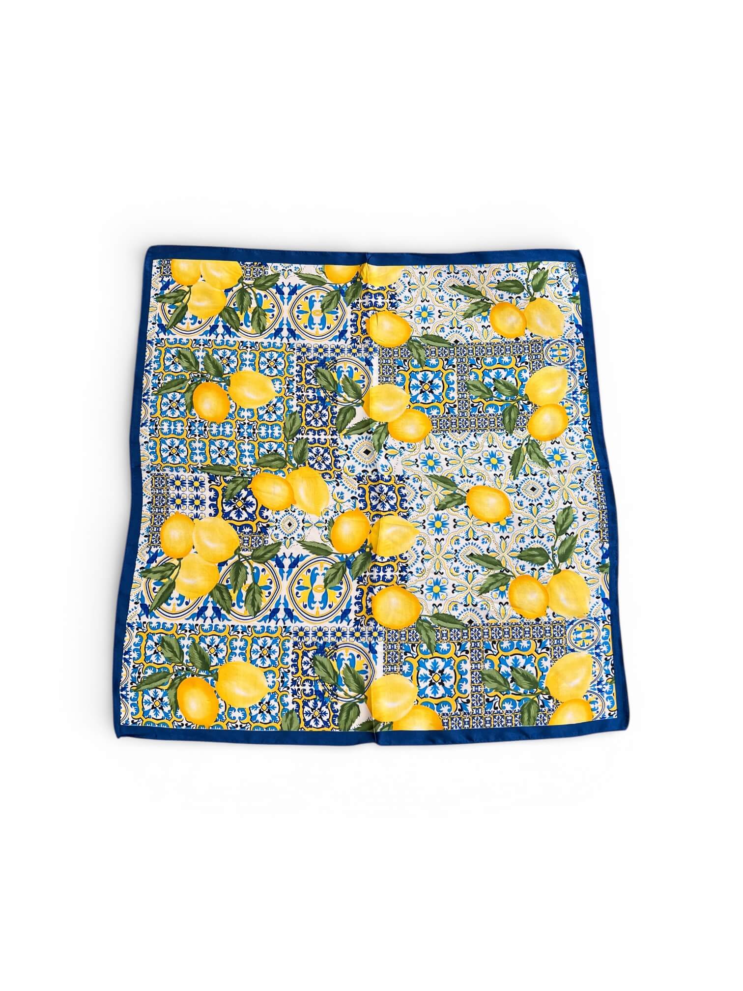 Quadratisches Tuch mit gelben Zitronen, blau-weißem Kachelmuster und dunkelblauem Rand liegt flach ausgebreitet auf hellem Hintergrund.
