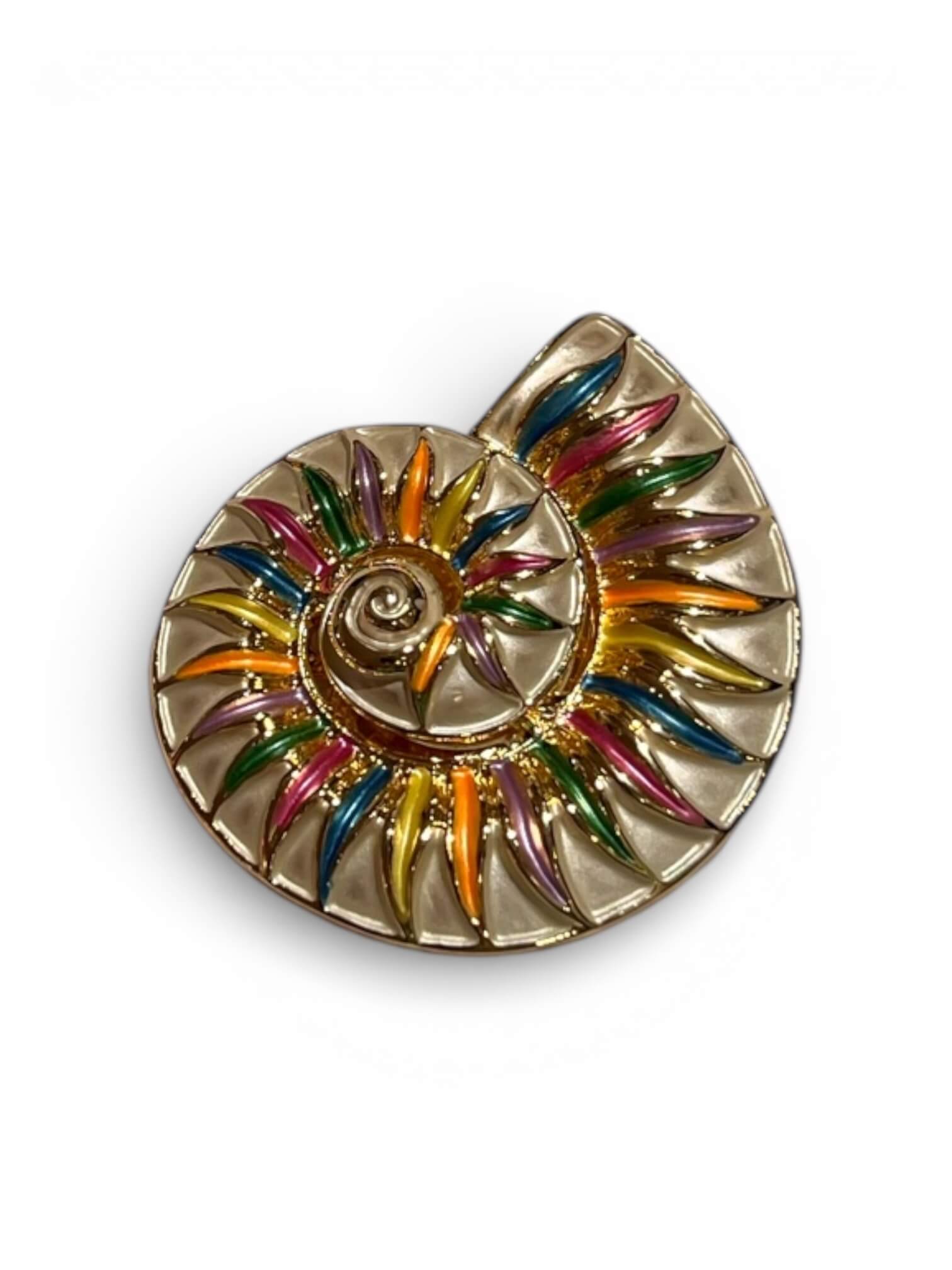 Magnetbrosche in Form einer stilisierten Muschel in Gold mit mehrfarbigen Emaille-Elementen in Blau, Grün, Pink, Orange und Violett, freigestellt vor hellem Hintergrund.