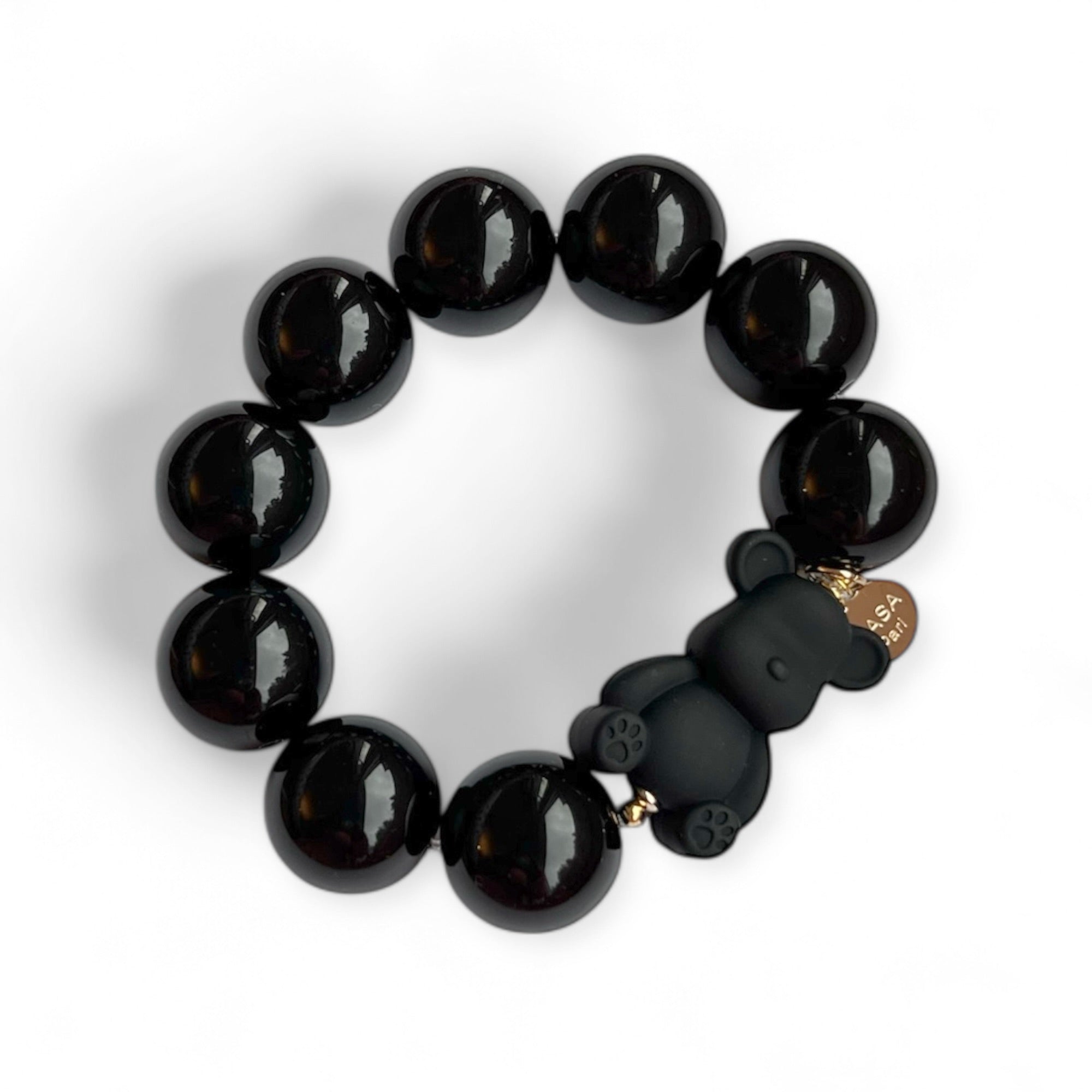 Armband aus schwarzen Kunstharzperlen mit einem kleinen schwarzen Bärenelement, handgefertigt von Casapari auf weißem Hintergrund.