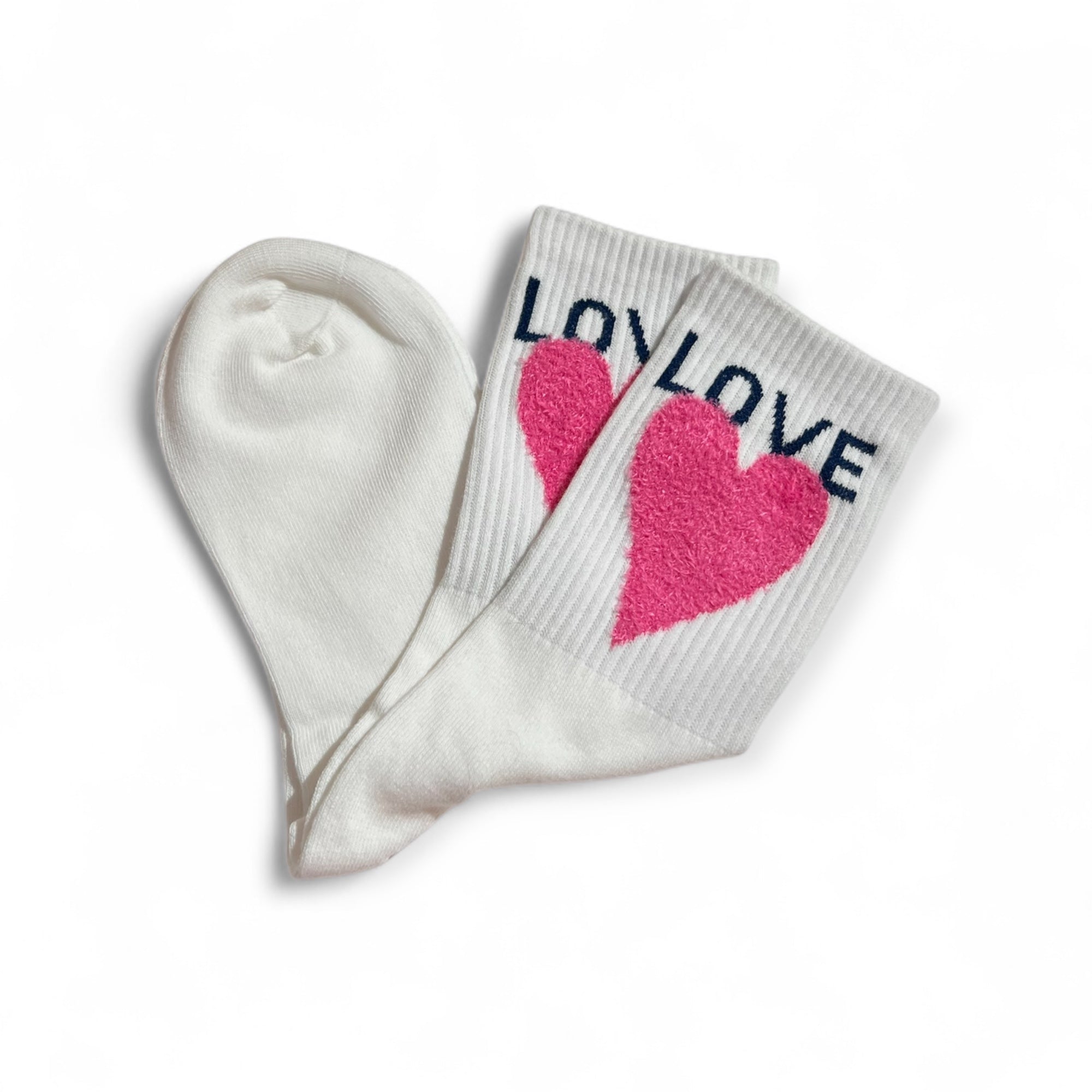 Weiße Strümpfe mit pinkfarbenem Herzmotiv und dem Schriftzug LOVE am Bund. Flauschige Struktur auf dem herz, flach liegend auf weißem Hintergrund.
