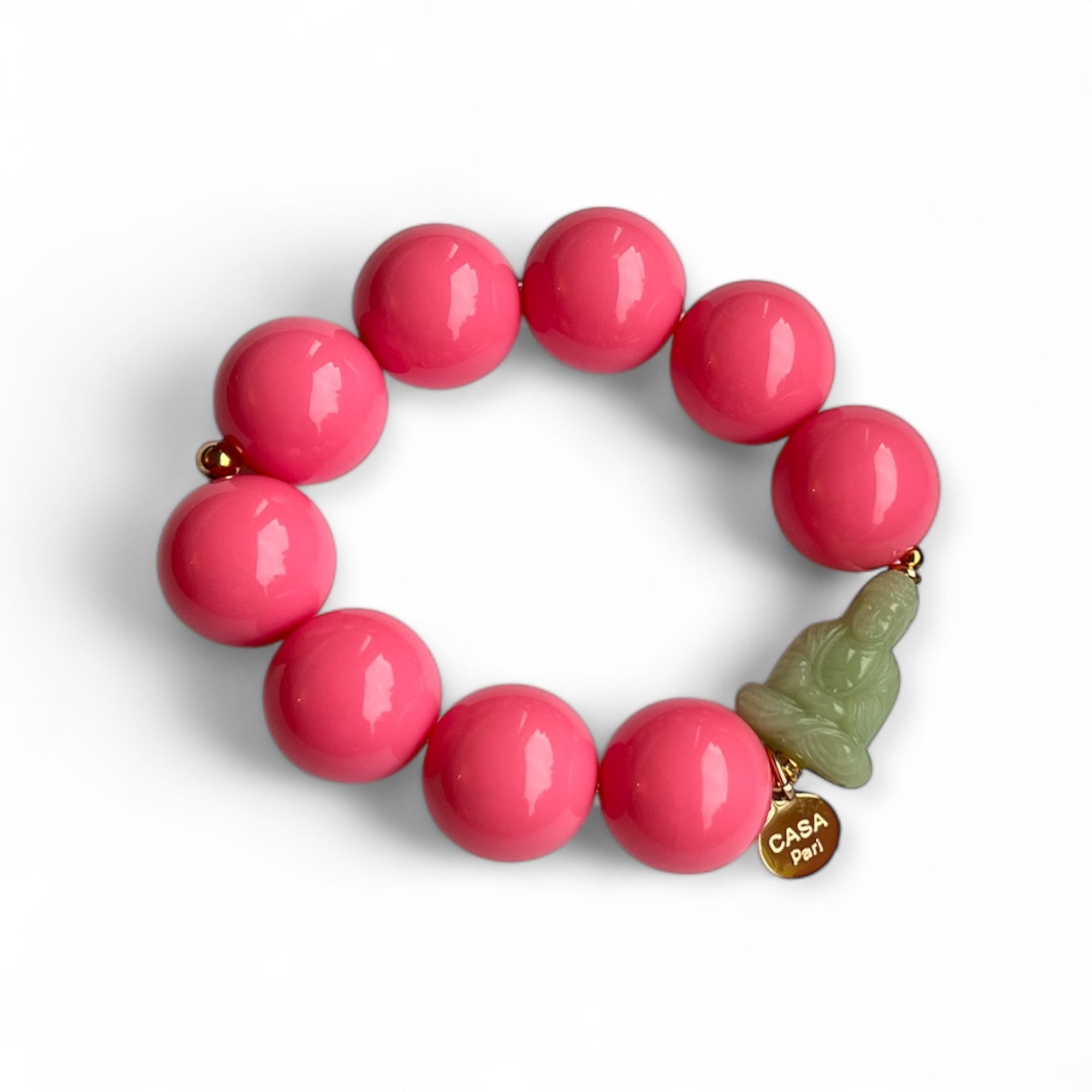 Pink rosa Armband aus glänzenden Kunstharzperlen mit einem kleinen Buddha Element. Handgefertigt von Casapari auf weißem Hintergrund.