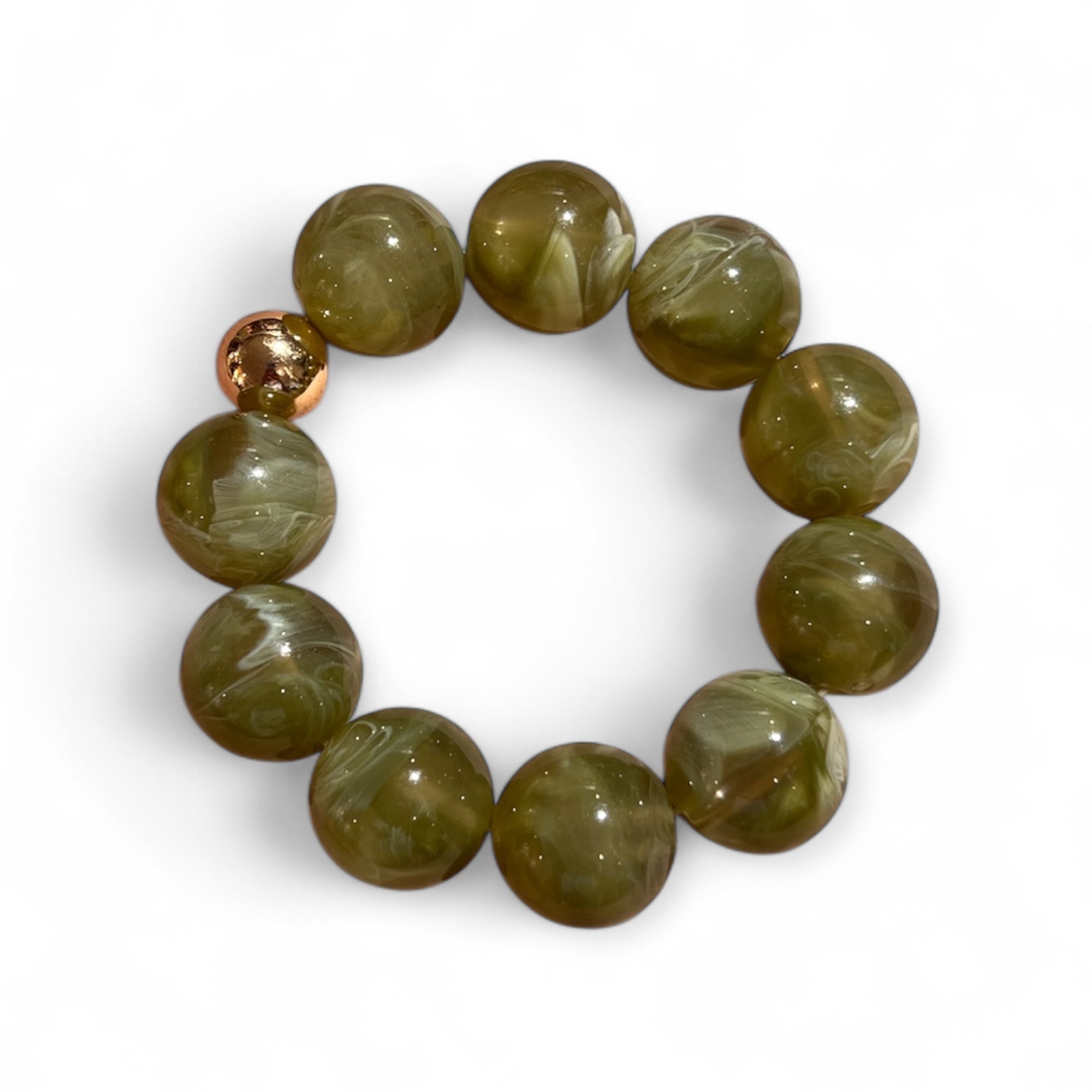 Armband aus olivgrünen, marmorierten Kunstharzperlen mit einer goldfarbenen Kugel. Liegt kreisförmig auf weißem Hintergrund.