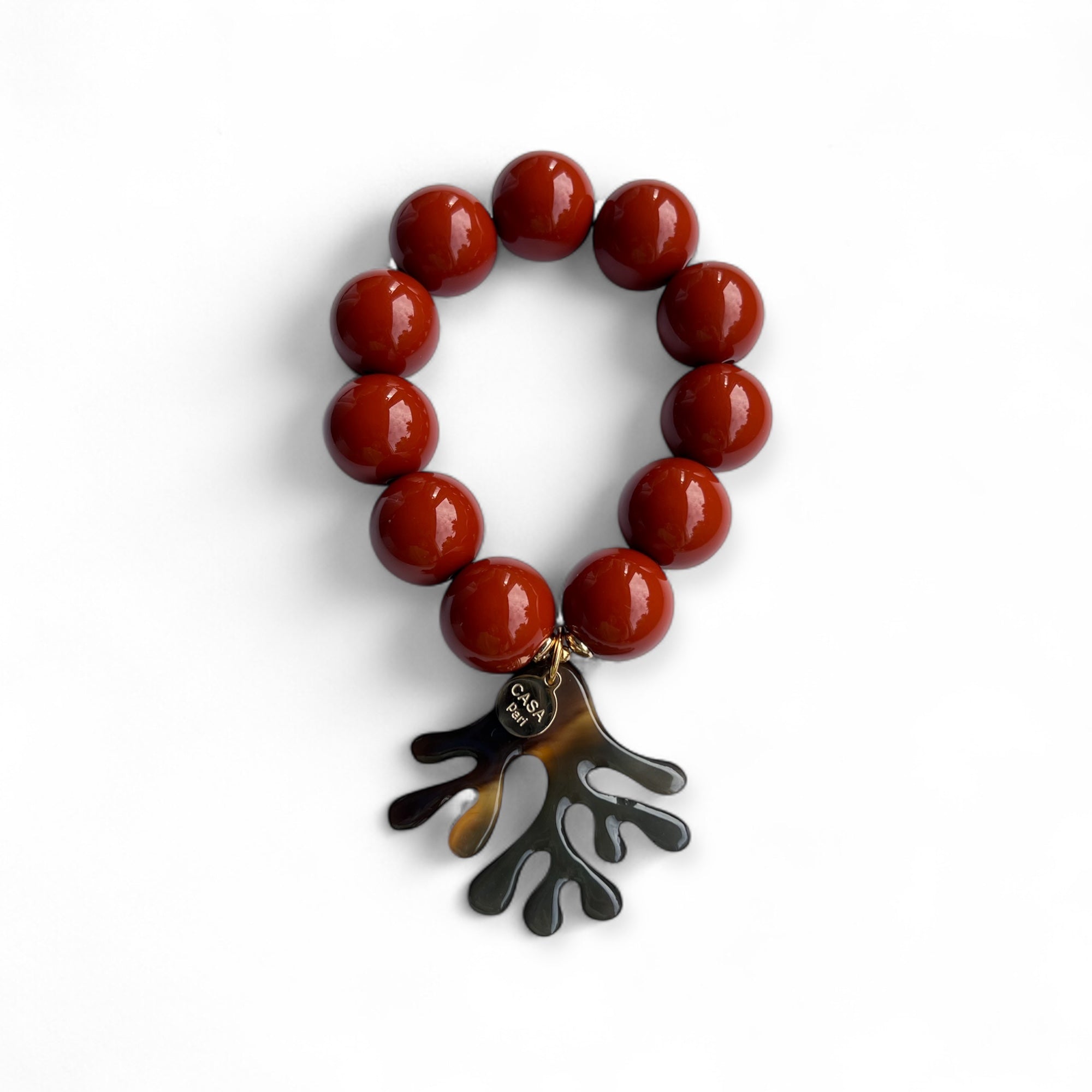 Armband mit großen Kunstharz Perlen in Haselnussfarben mit echtem Büffelhorn Anhänger in Korallenform. Handgefertigtes Schmuckstück von CASAPARI®.