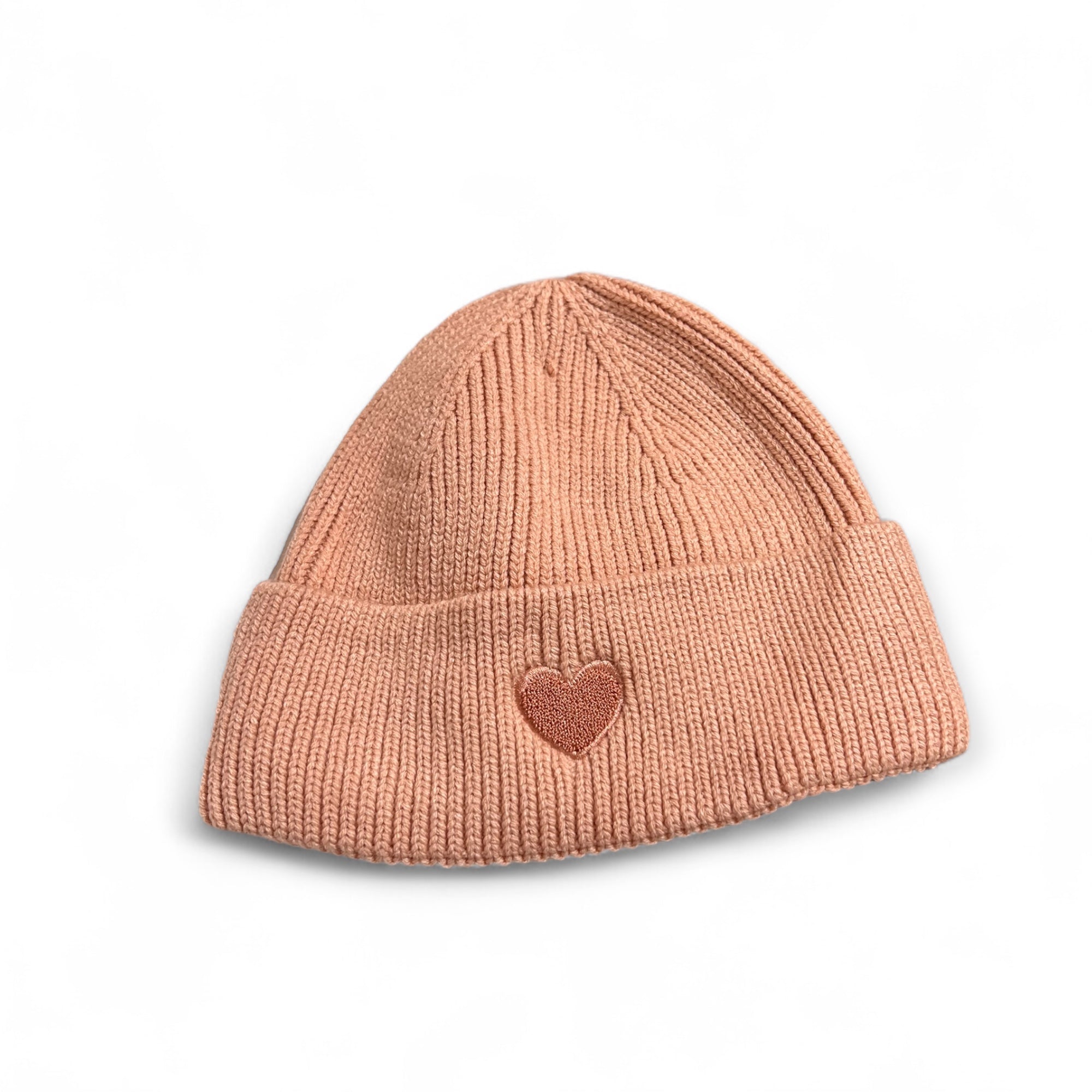 Apricot Strickmütze aus Viskose mit aufgesticktem rotem Herz auf der Vorderseite, fotografiert auf weißem Hintergrund.